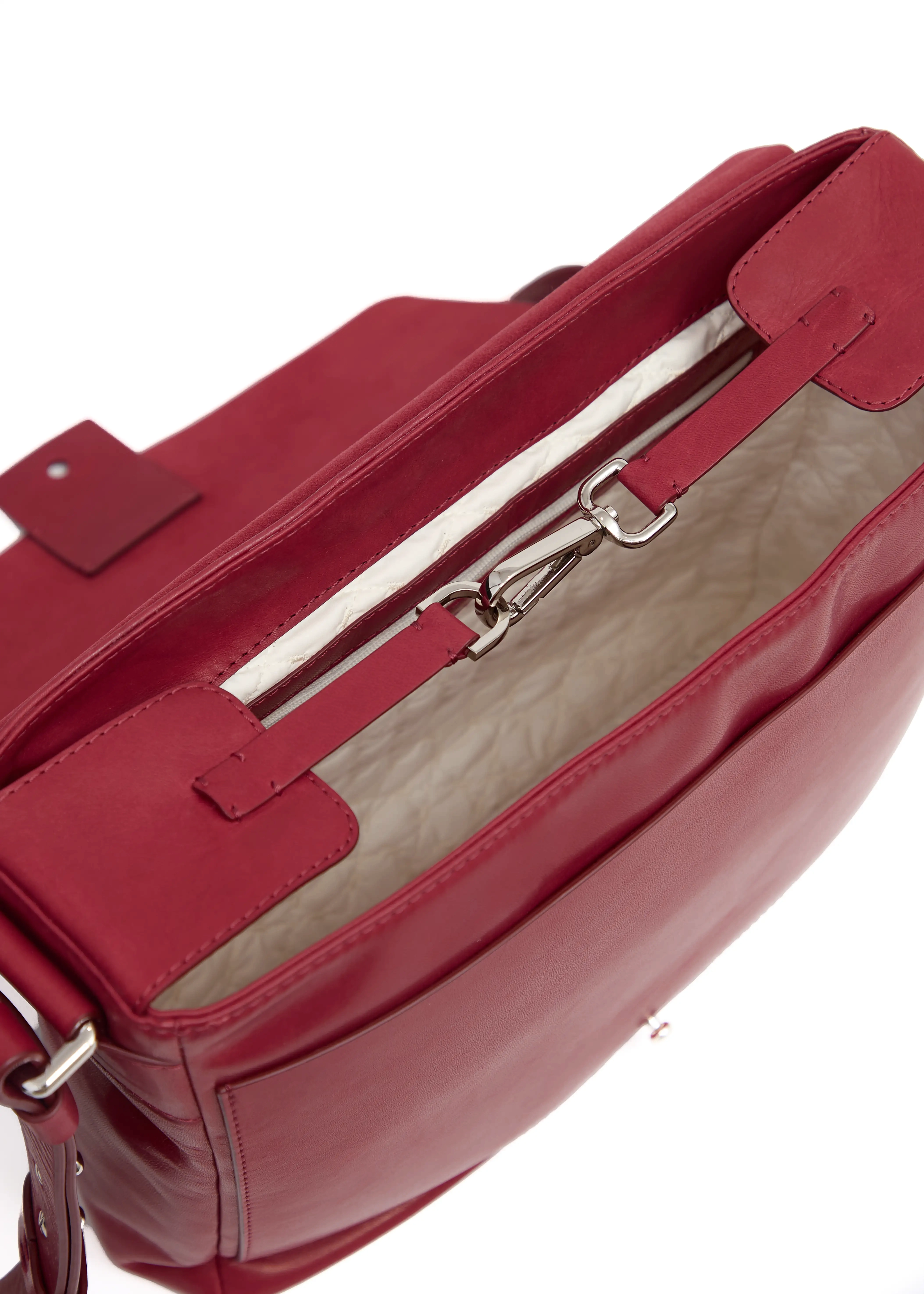 Close-up of the inside of Philini Aneta Bag, with a top clasp, featuring a silver carabiner and leather shaping plates with silver details securing the bag's opening