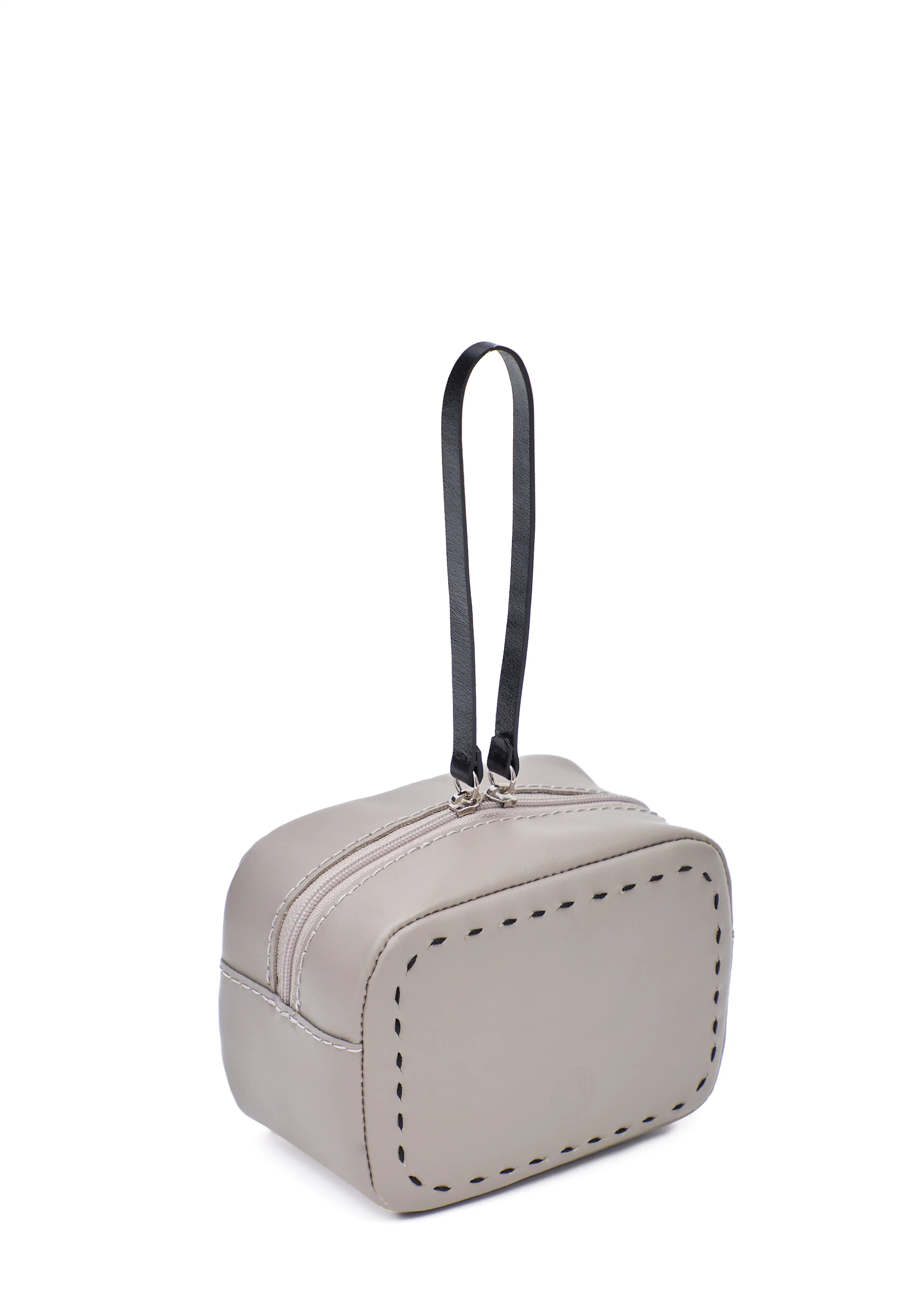 Side view of the Philini Anny taupe leather cosmetic bag, boxy silhouette with zip closure, leather pull, and hand-stitched details. Compact leather toiletry bag