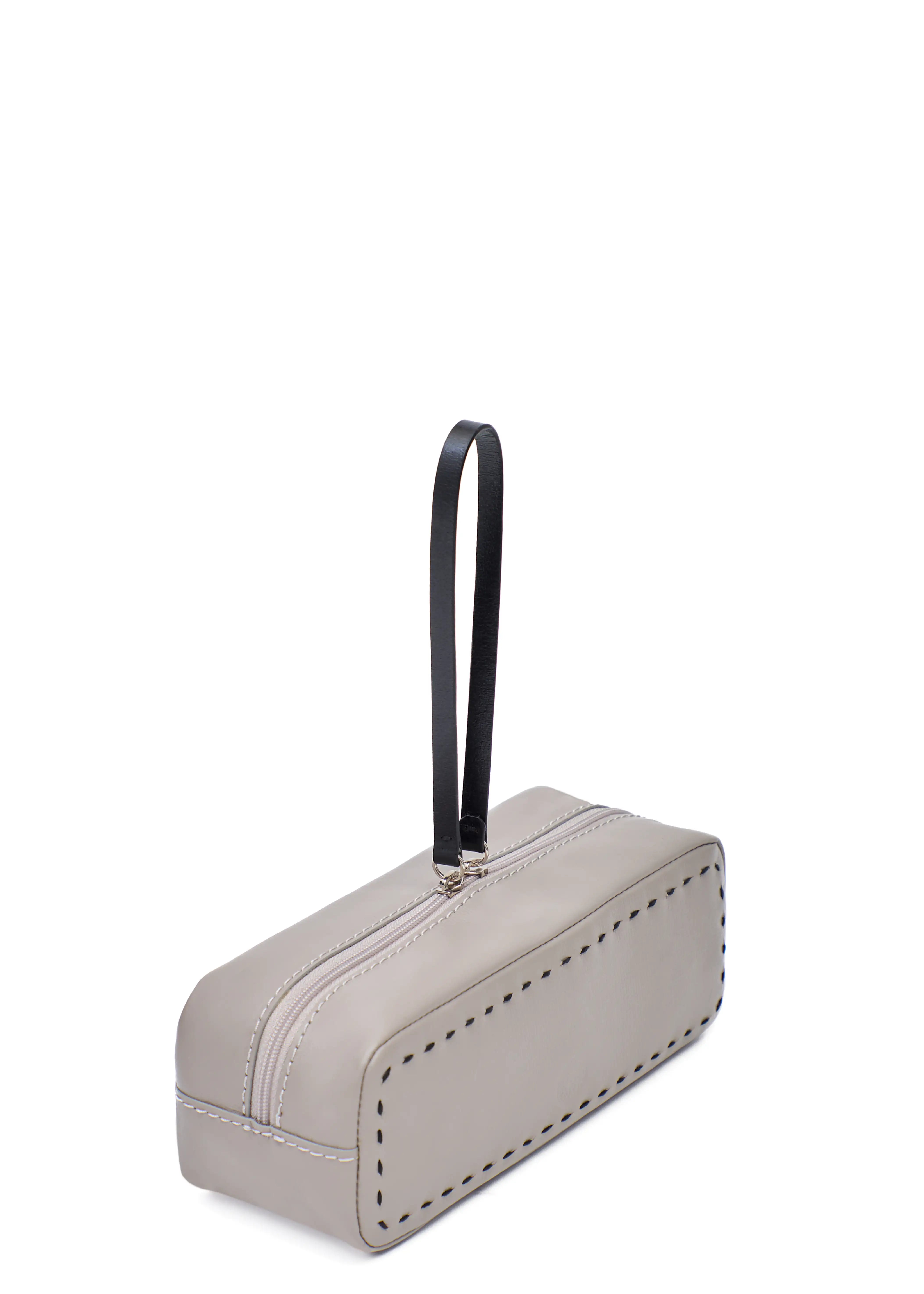 Side view of the Philini Ellie Cosmetic Bag in taupe aniline leather, showing hand-stitched details and zip closure with leather pull. Minimalist small leather makeup bag,