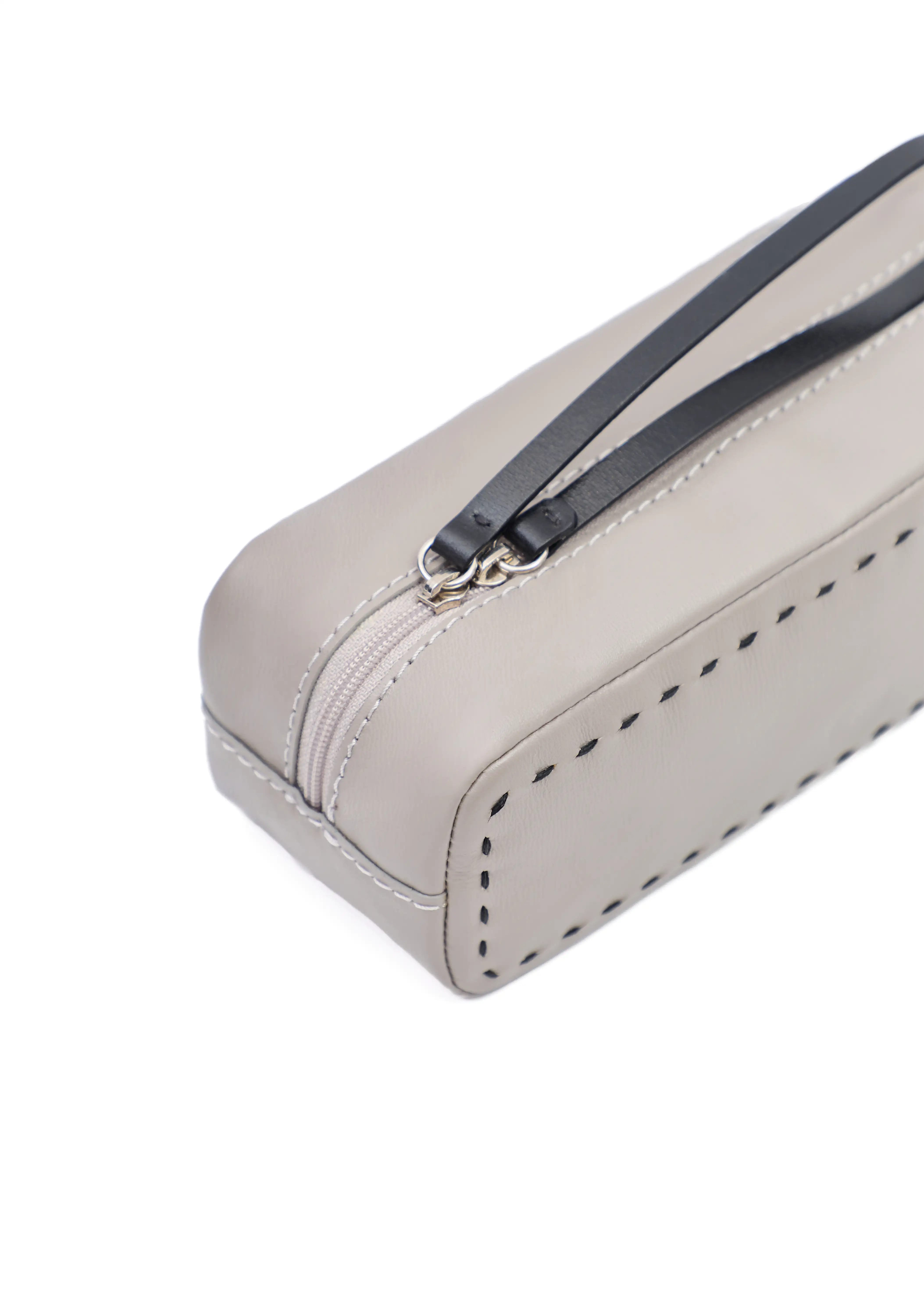 Close detail view of the Philini Ellie Cosmetic Bag in a compact rectangular shape, crafted from taupe aniline leather. Features a zip closure with a leather pull and hand-stitched finish. Minimalist leather makeup bag