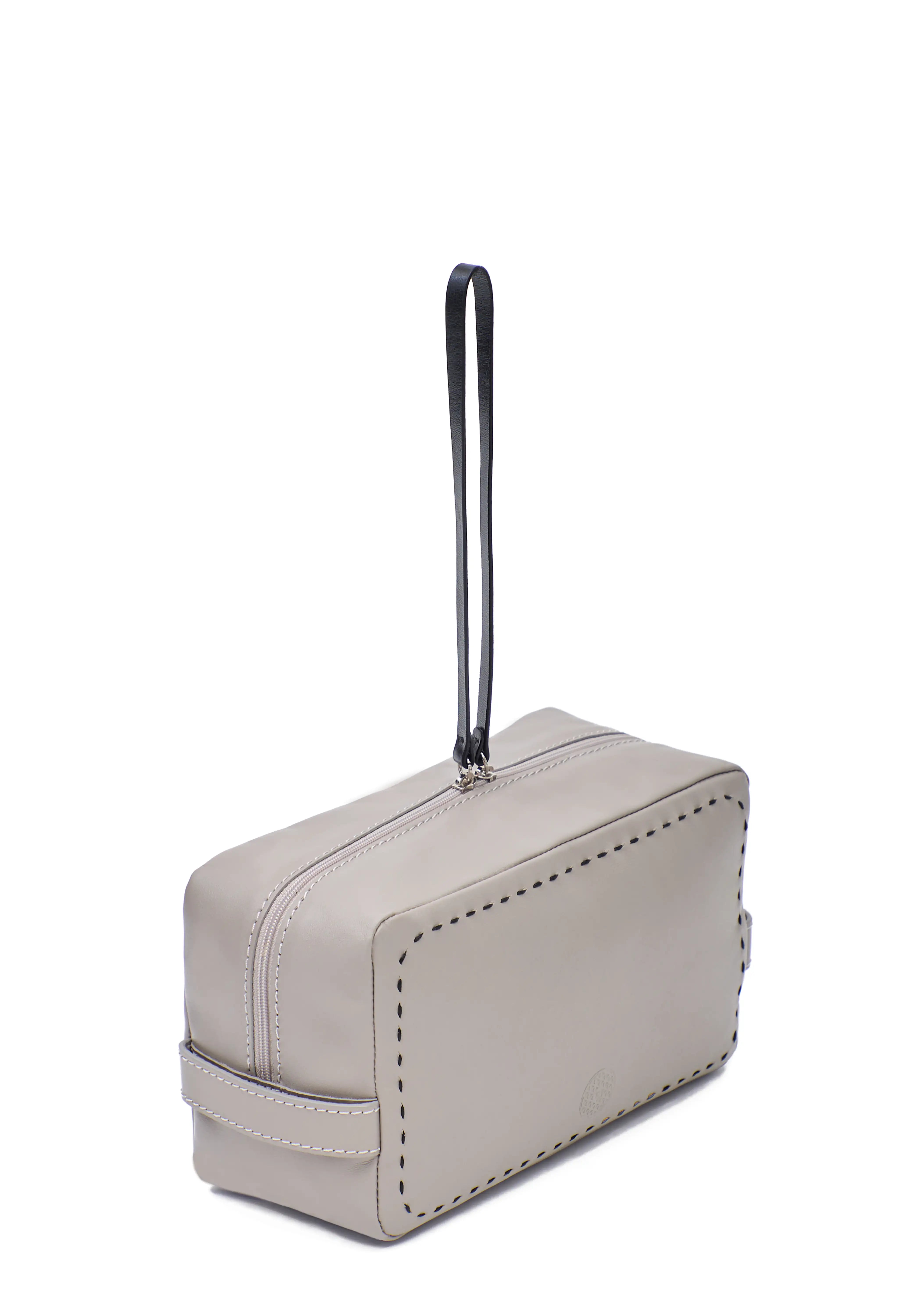 Side view of the Philini Magdalena Pouch in taupe leather, showing short side handles, zip closure with leather pull, and hand-stitched edges. Minimalist small leather pouch, ideal as a travel or makeup bag