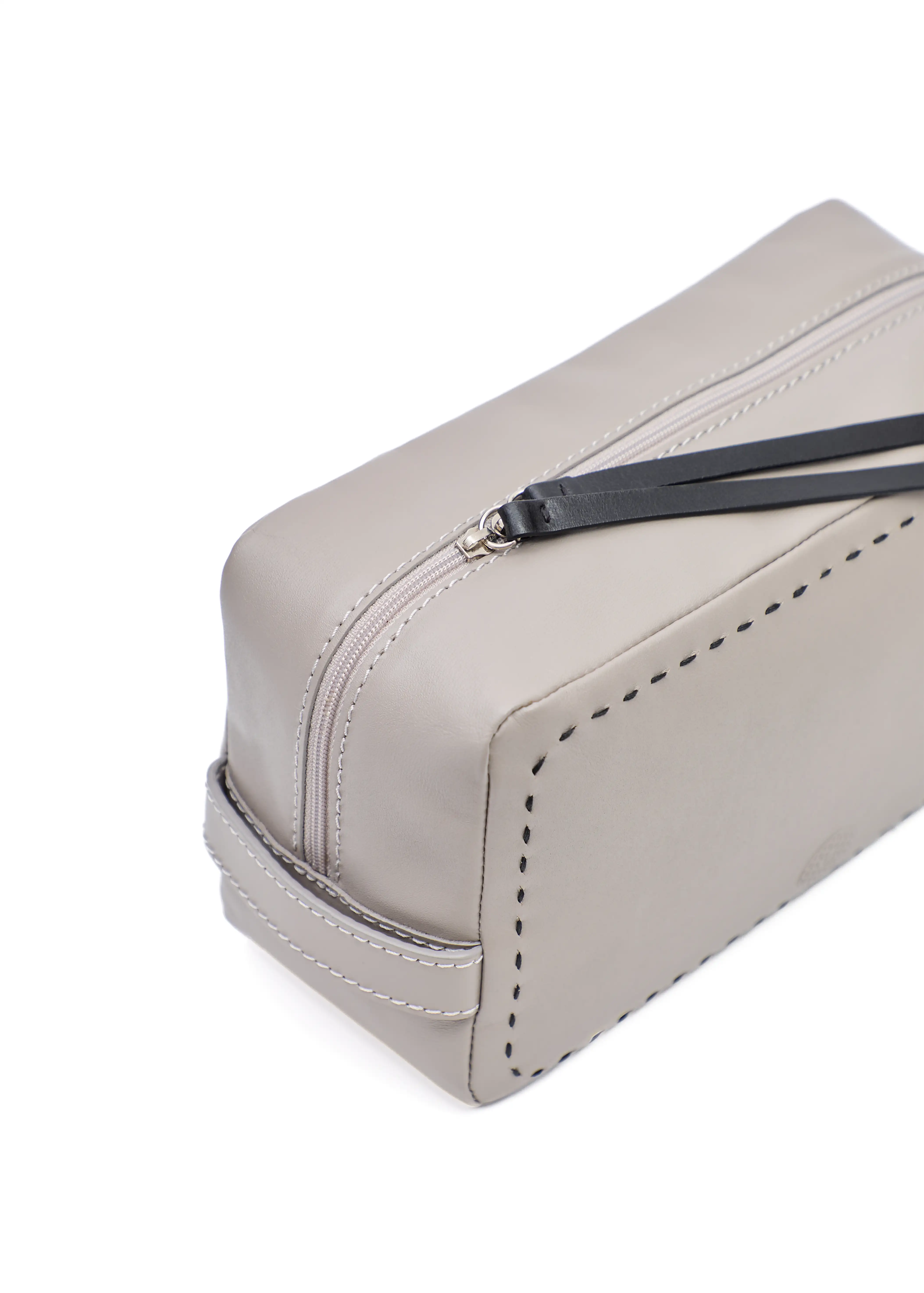 Close side view of the Philini Magdalena Pouch in taupe leather, showing short handle, zip closure with leather pull, and detailed hand-stitched edge