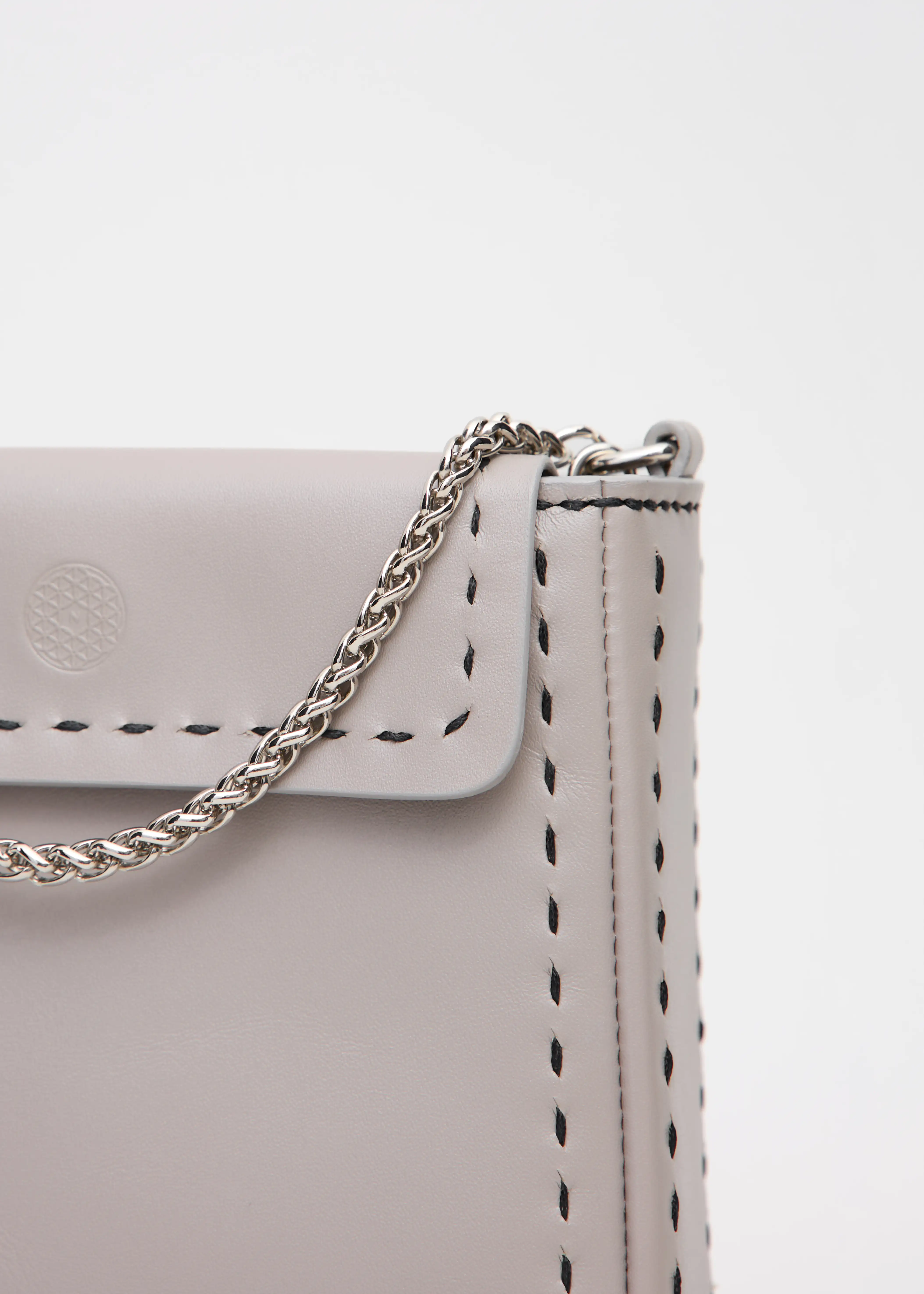Detailed view of the Philini Saphira Purse in taupe aniline leather, compact rectangular shape with hand-stitched details, sleek half-lap flap, and convertible chain and leather straps. Elegant handmade leather evening purse.