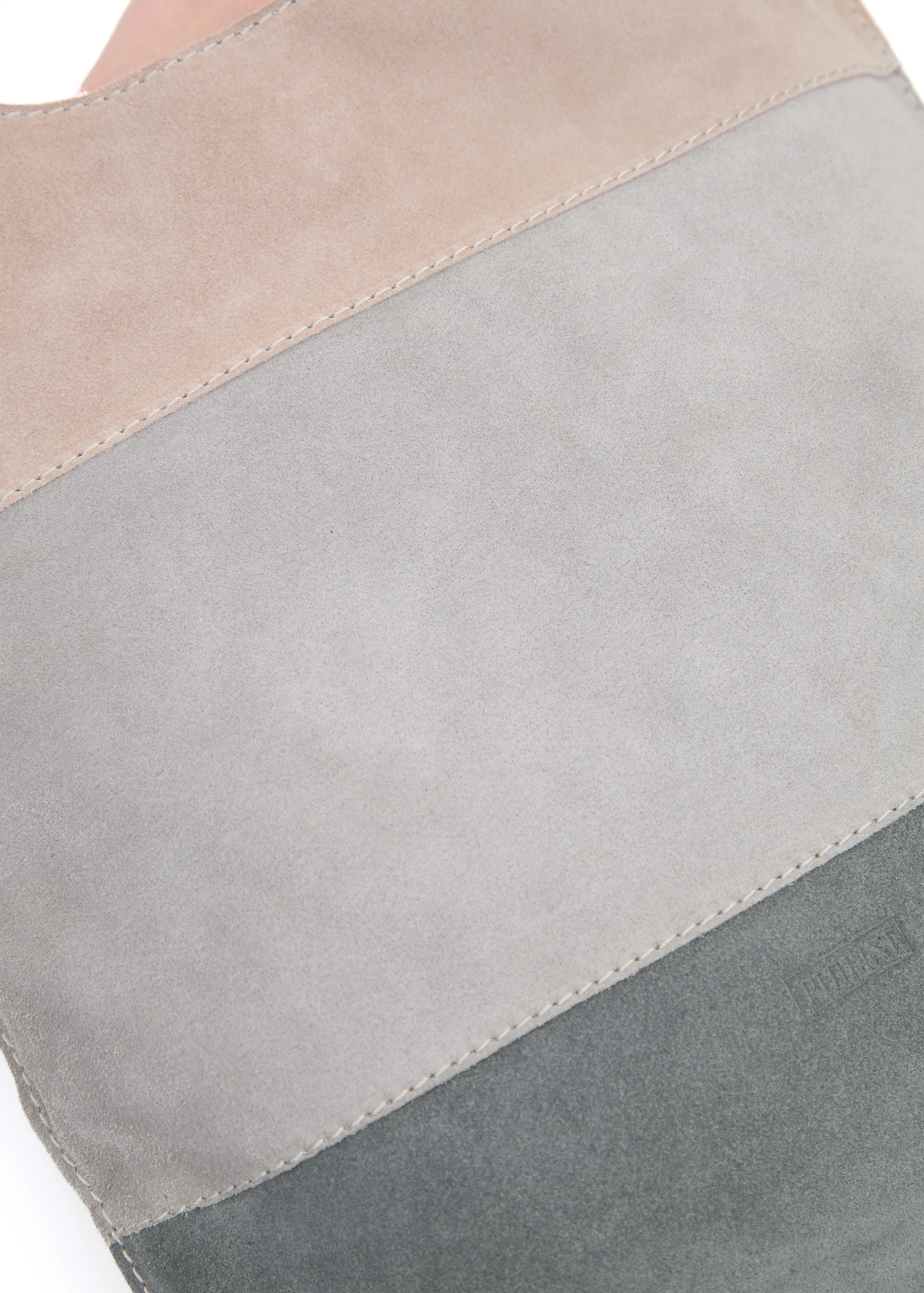 Close-up of the Philini Semfira Hobo Bag in grey suede, focusing on the color strap combination, suede finish, stamped Philini logo, and fine stitching. High-quality suede fashion bag