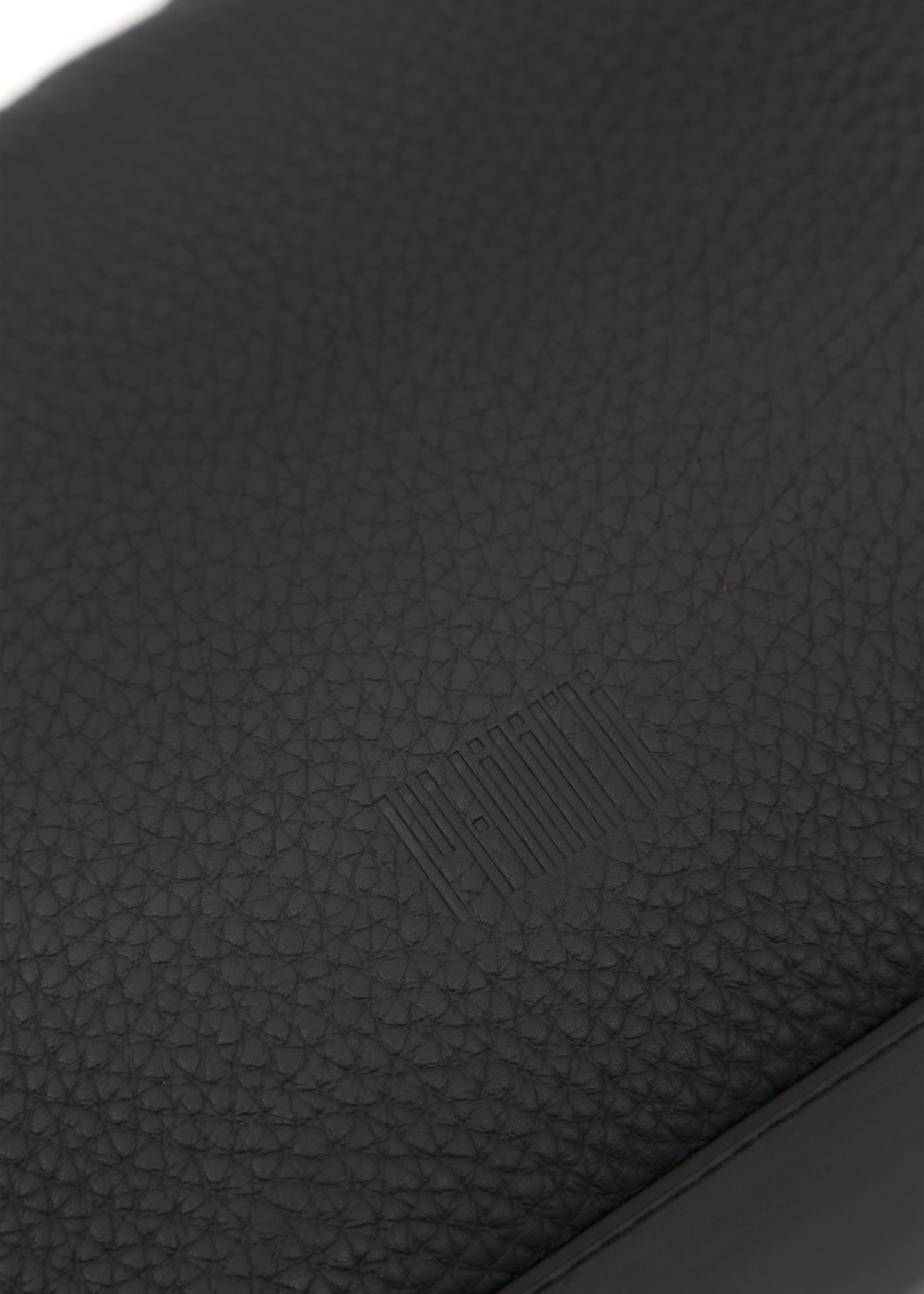 Close-up of high-quality black buffalo leather with a stamped Philini logo, featured on the front of the Yana Hobo Bag