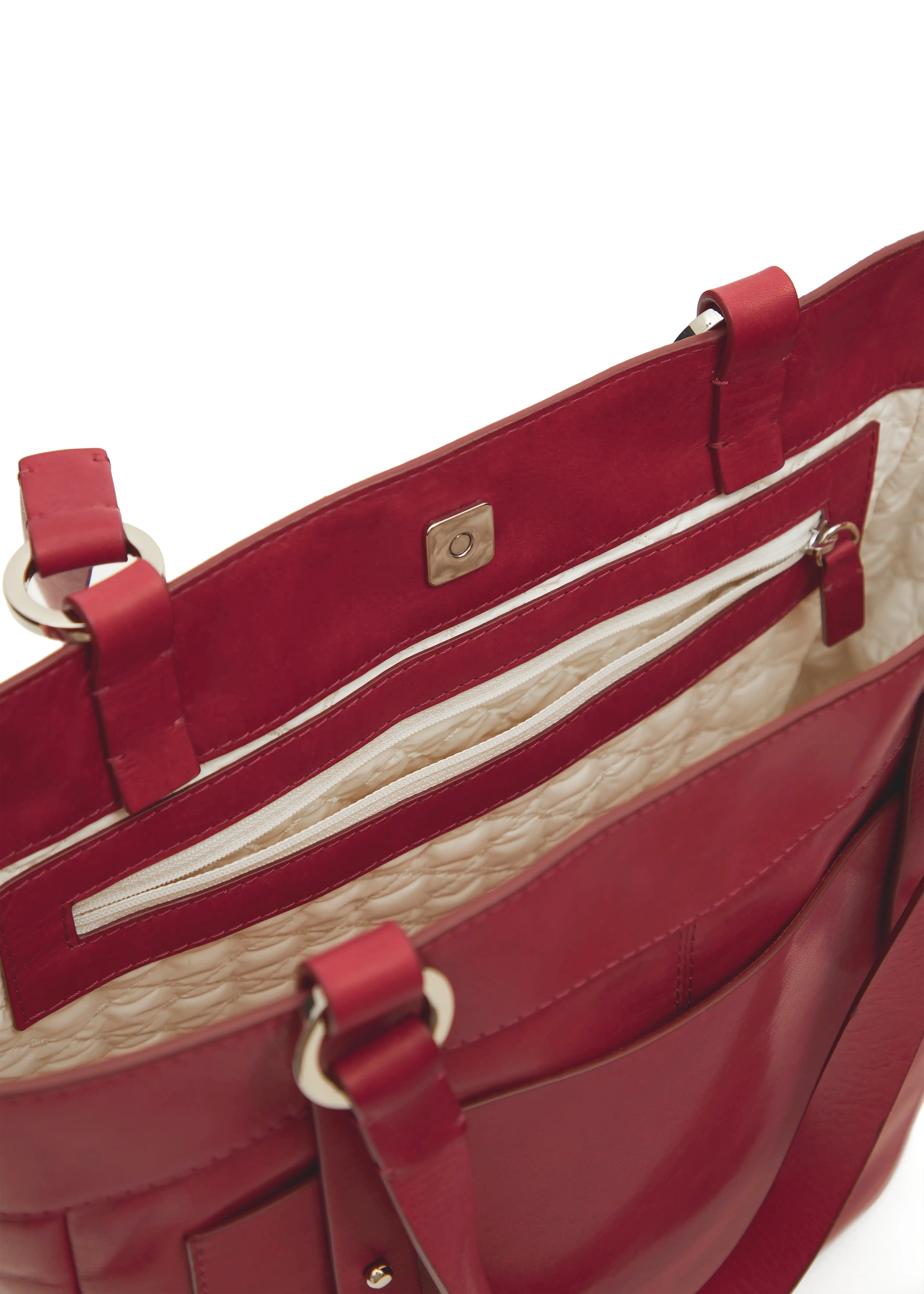 Interior view of the Philini Elena Red Tote Bag, featuring a square magnetic closure and a deep zippered pocket in the lining. Crafted from premium leather with silver-colored hardware on the handles