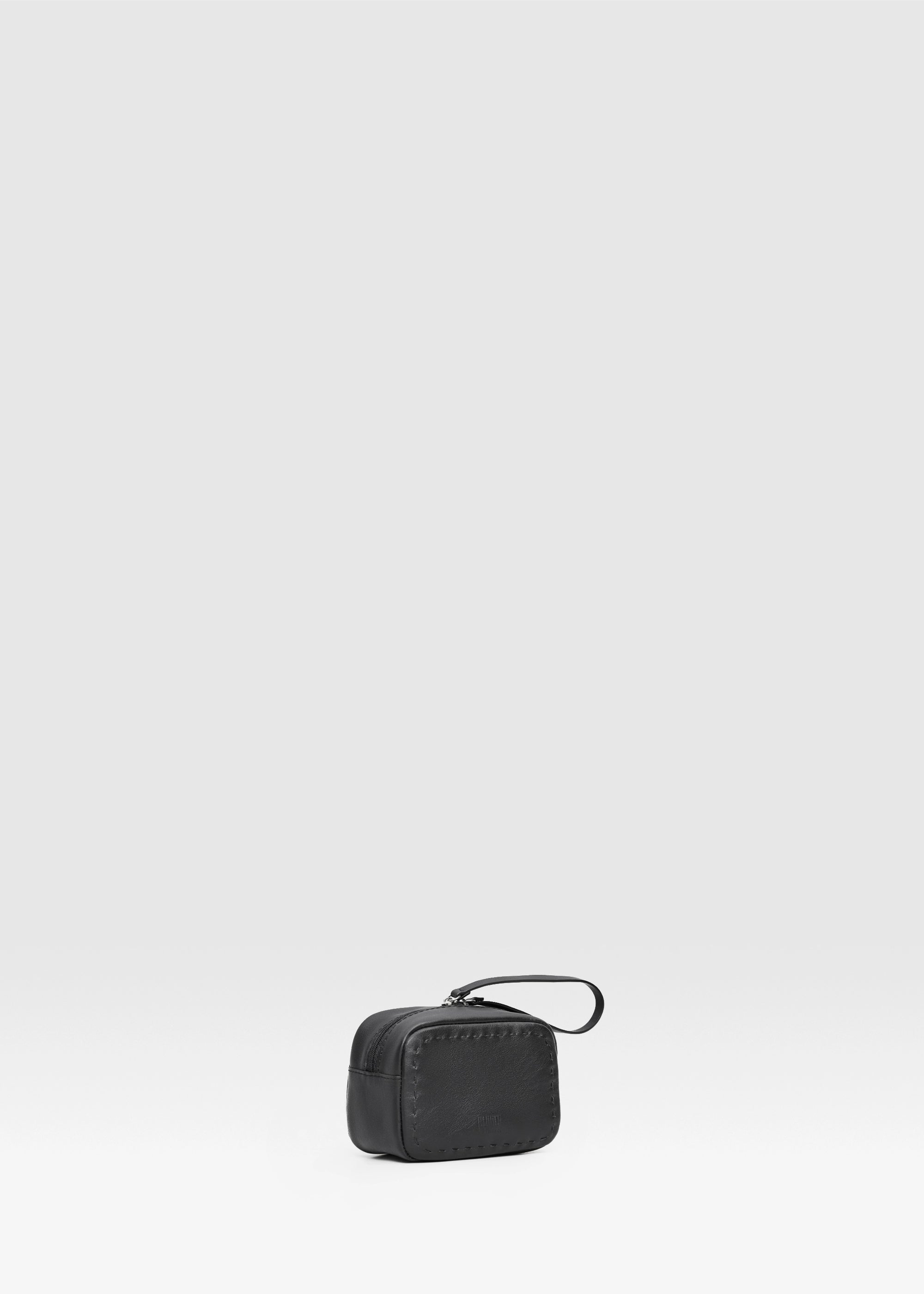Side view of the Philini Anny Cosmetic Bag in black aniline leather, featuring a structured  shape 