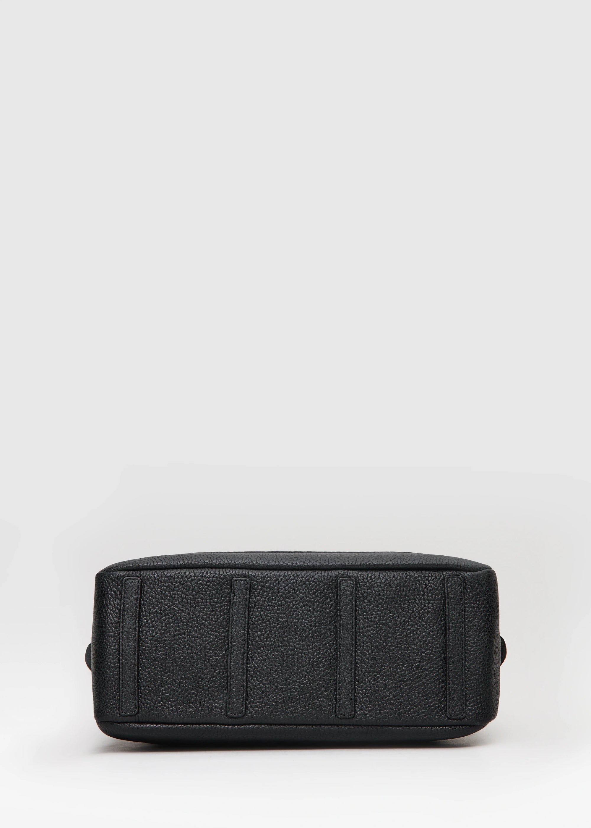 Bottom view of the Philini Domi Black Dome Handbag, crafted from premium buffalo leather with four small leather pads as protective feet. This sustainable leather bag is a timeless accessory, ideal for minimalist style