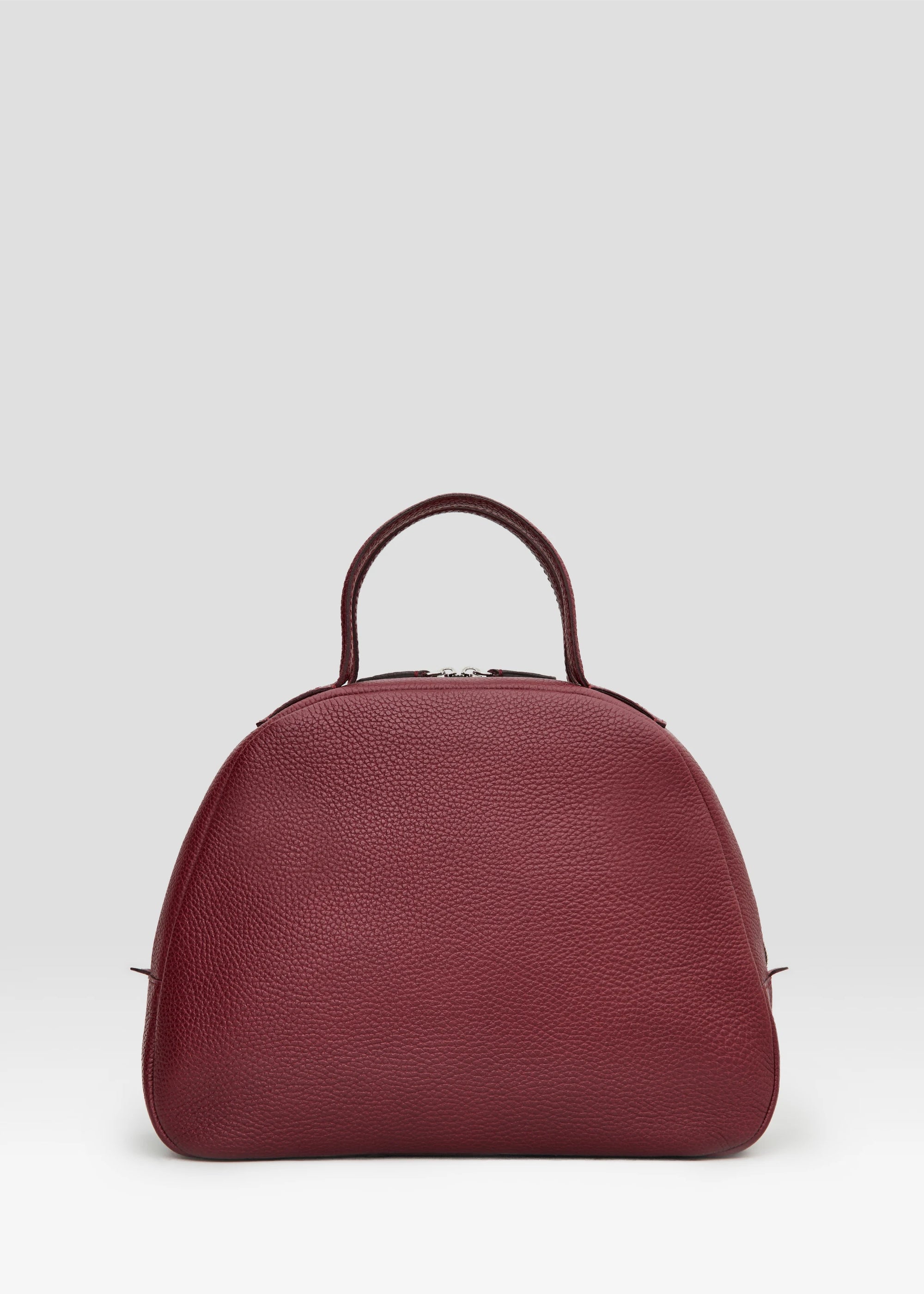 Back view of the Philini Domi Red Handbag in calf leather with short handles, silver rivets, and front zip pocket