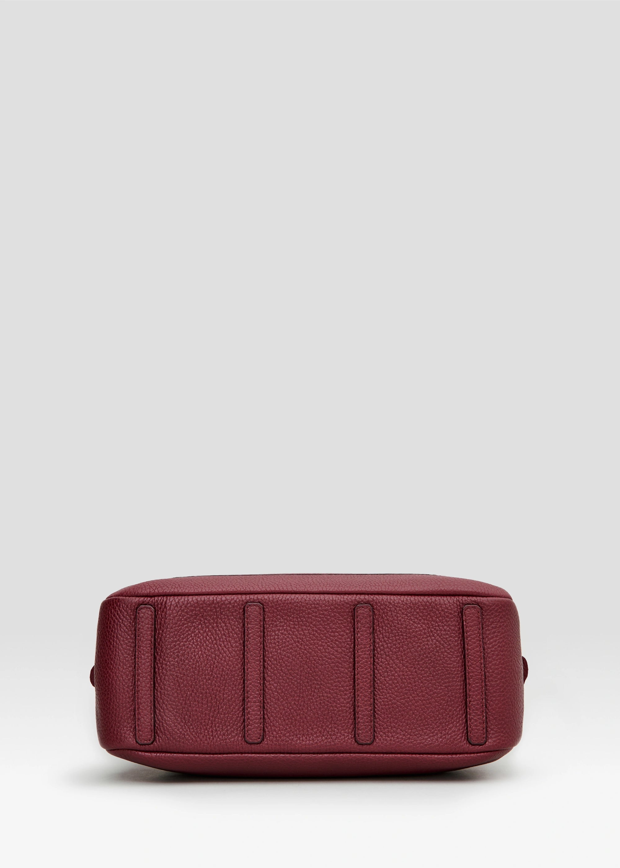 Bottom view of the Philini Domi Red Handbag in calf leather with short handles, silver rivets, and front zip pocket