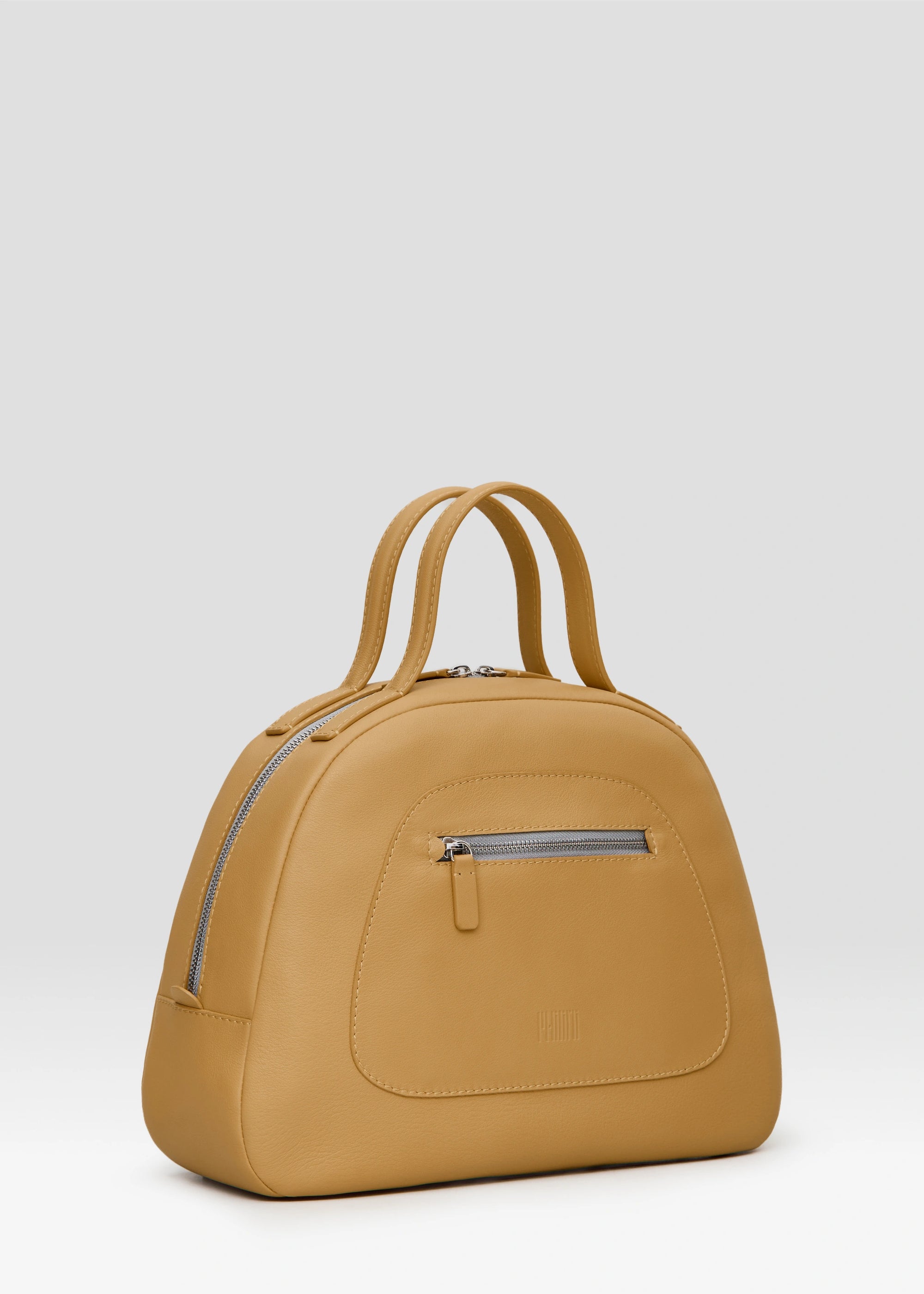 Side view of the Philini Domi Handbag in yellow nappa leather, showcasing the dome shape, short handles, silver rivets, front zip pocket, and zipper closure. This handcrafted luxury leather handbag is a sustainable craftsmanship for everyday elegance