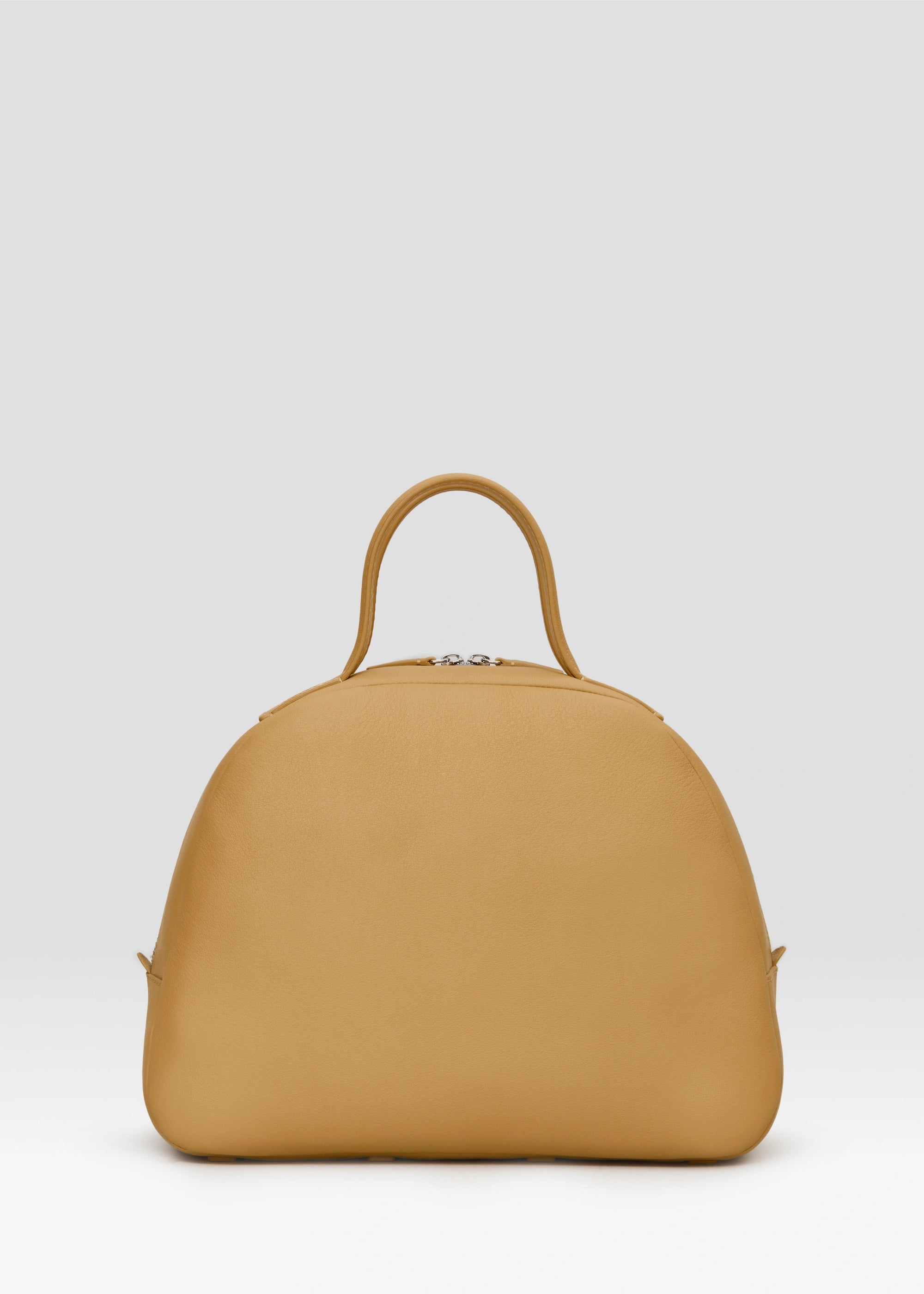 Back view of the Philini Domi Handbag in yellow nappa leather, featuring a dome shape, short handles, silver rivets, and zipper. Handmade leather bag with minimalist design