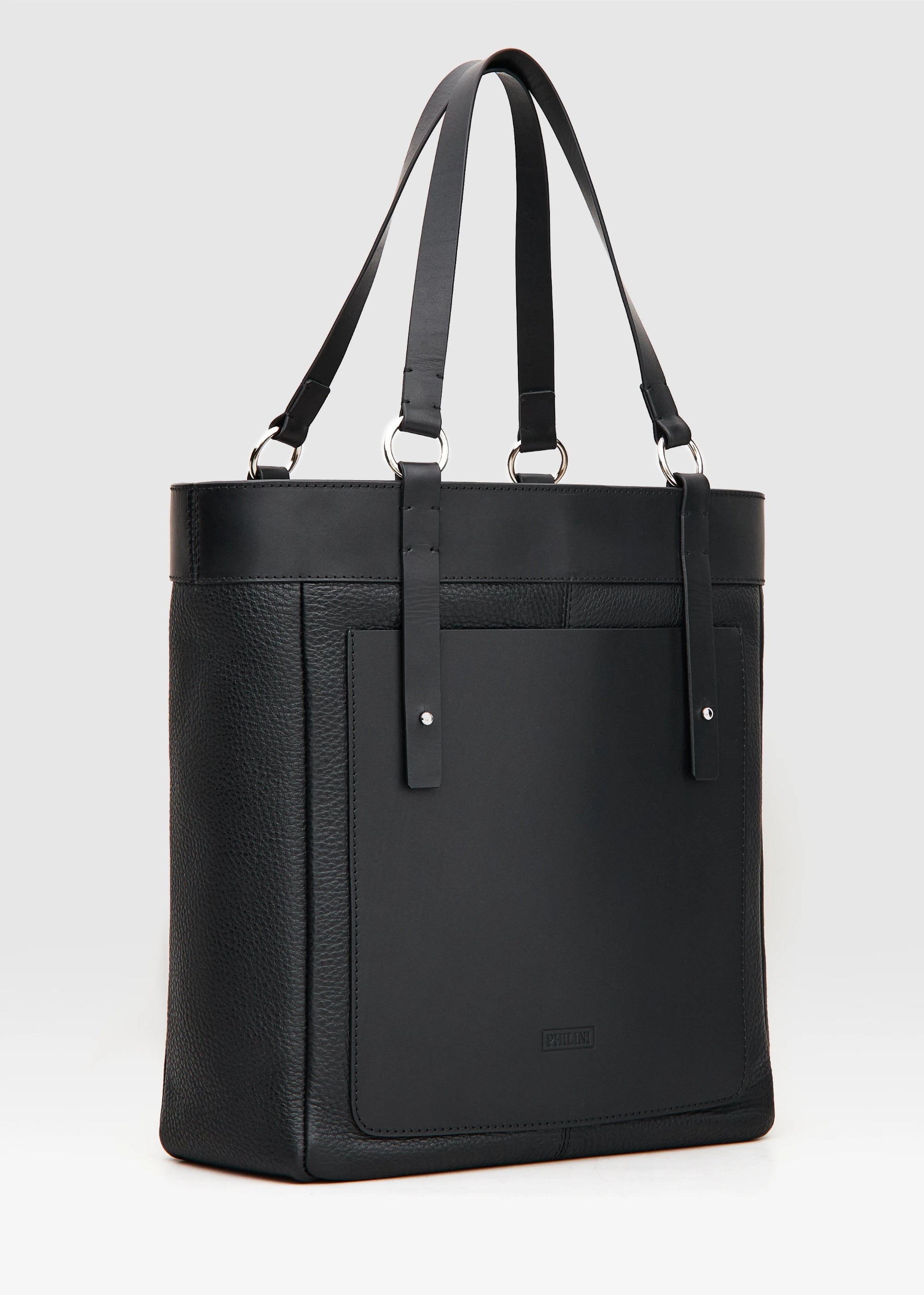 Side view of Philini Elena Black Tote Bag in two types of genuine leather, a full-grain leather exterior pocket and silver details on the sturdy handles. This timeless and eco-friendly bag is perfect for modern women seeking elegance and functionality.