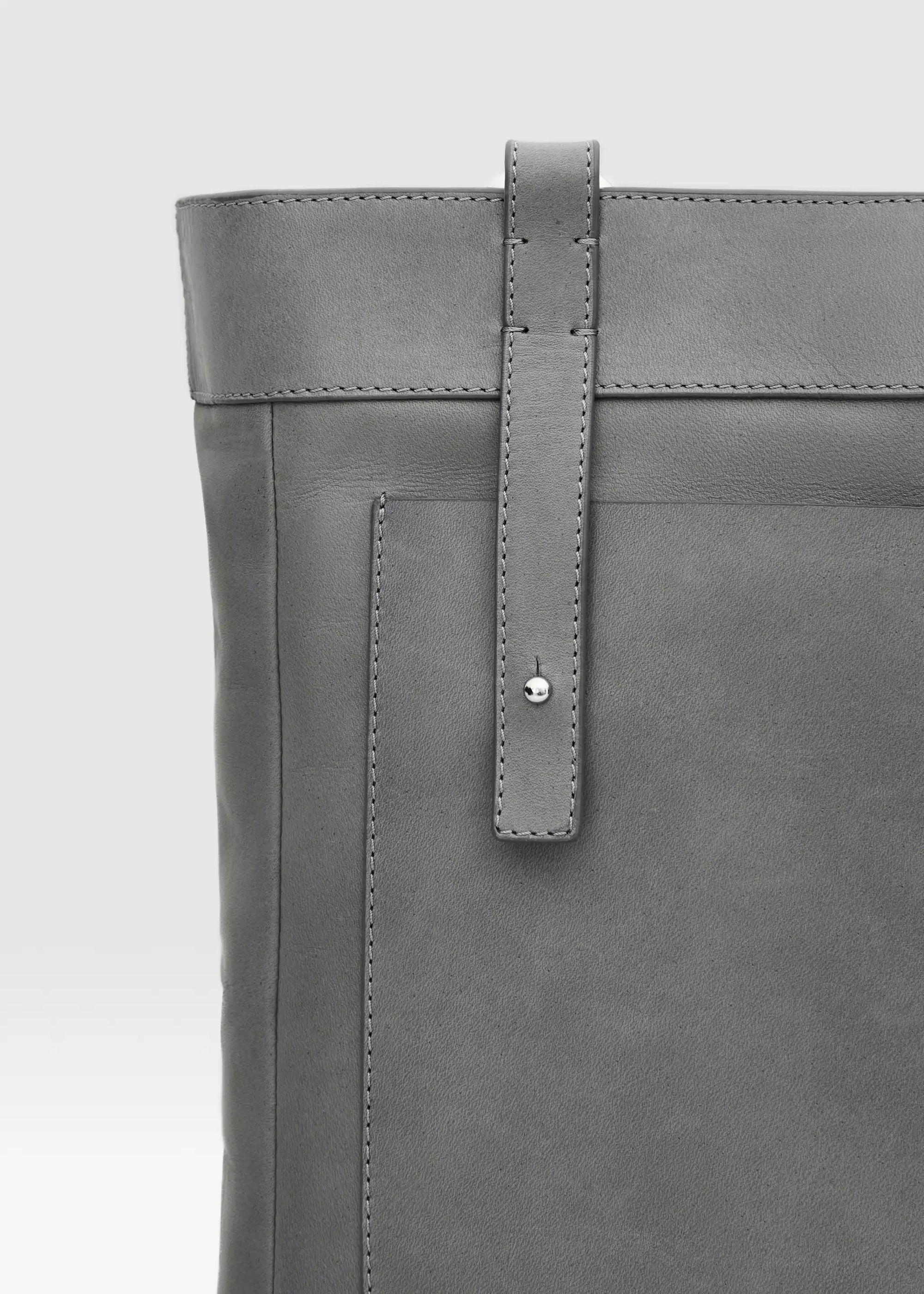 Detailed view of the Philini Elena Grey Tote Bag in red aniline leather, featuring a leather exterior pocket and silver hoop accents on the handles.