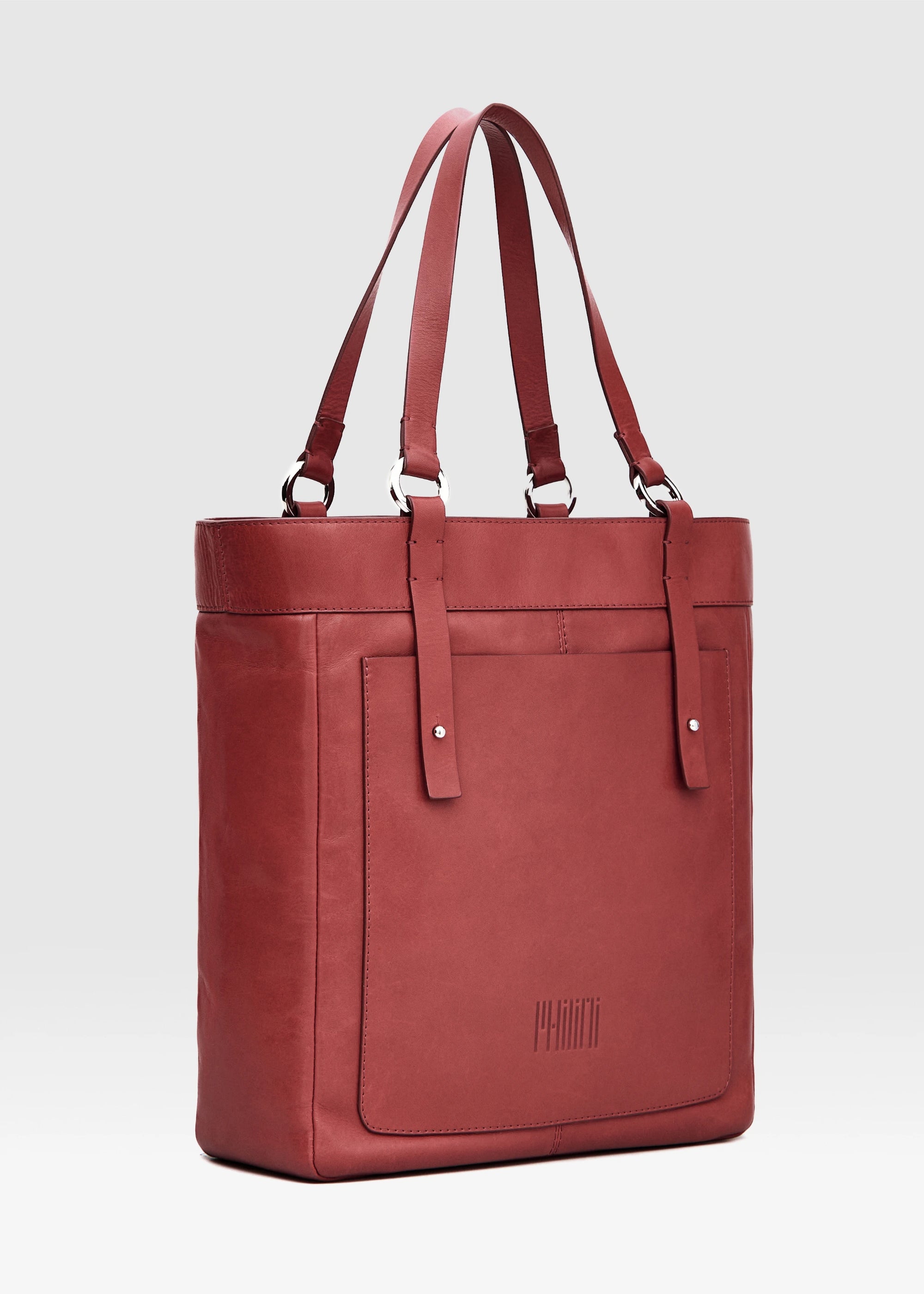 Side view of the Philini Elena Red Tote Bag in red aniline leather, featuring a leather exterior pocket and silver hoop accents on the handles. This sustainable tote combines modern elegance with practical design