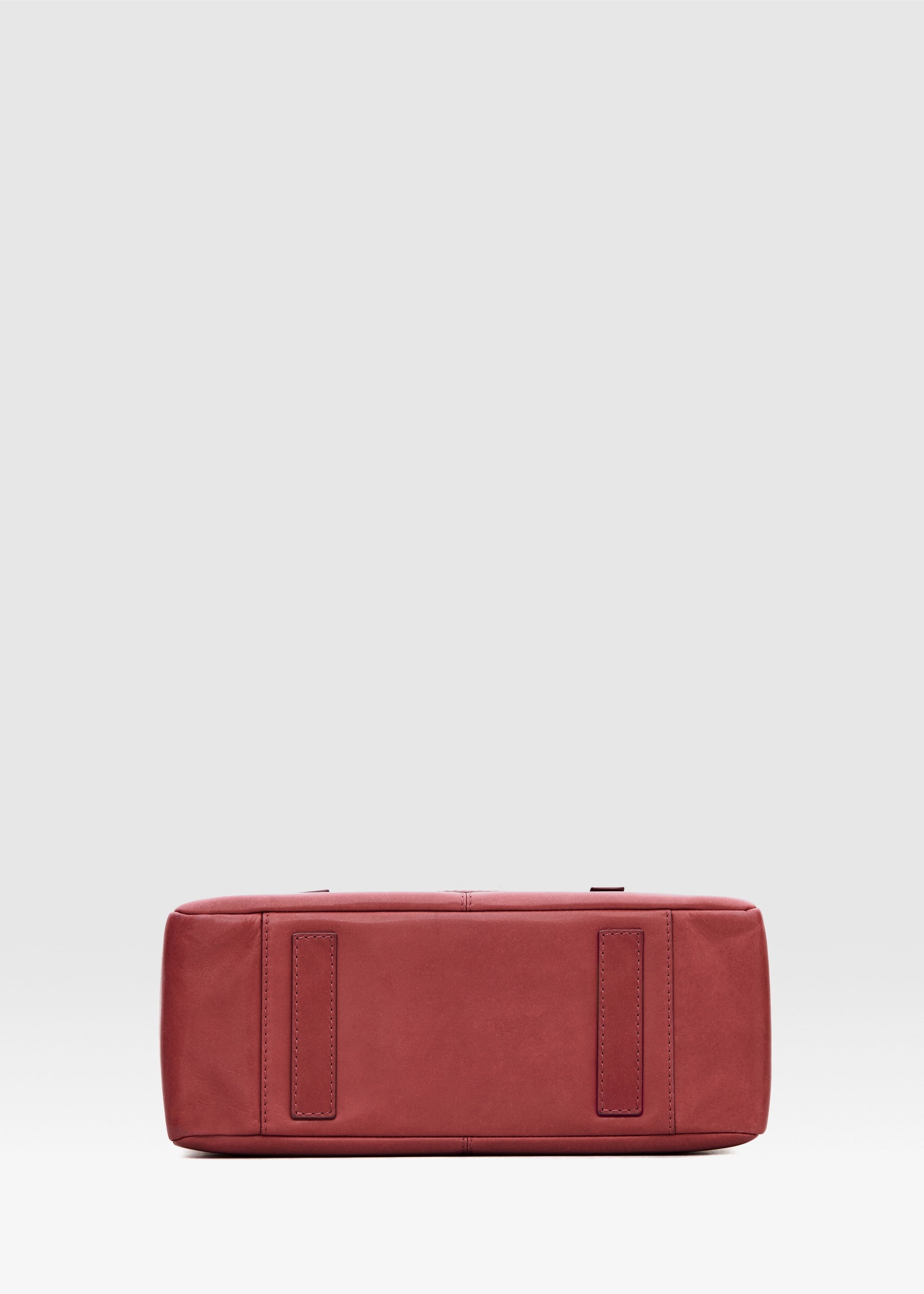 Bottom view of the Philini Elena Red Tote Bag in red aniline leather, featuring two small leather pads that serve as protective feet. This handcrafted tote embodies eco-conscious fashion and premium quality.
