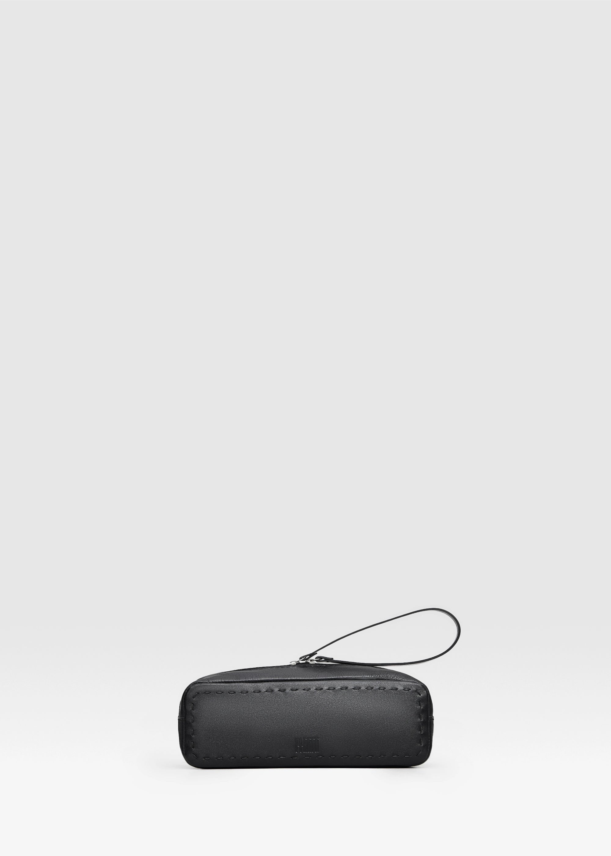 Front view of the Philini Ellie Cosmetic Bag in black aniline leather, showcasing its sleek zip closure with a leather pull and fine handcrafted stitching. Elegant compact leather toiletry pouch