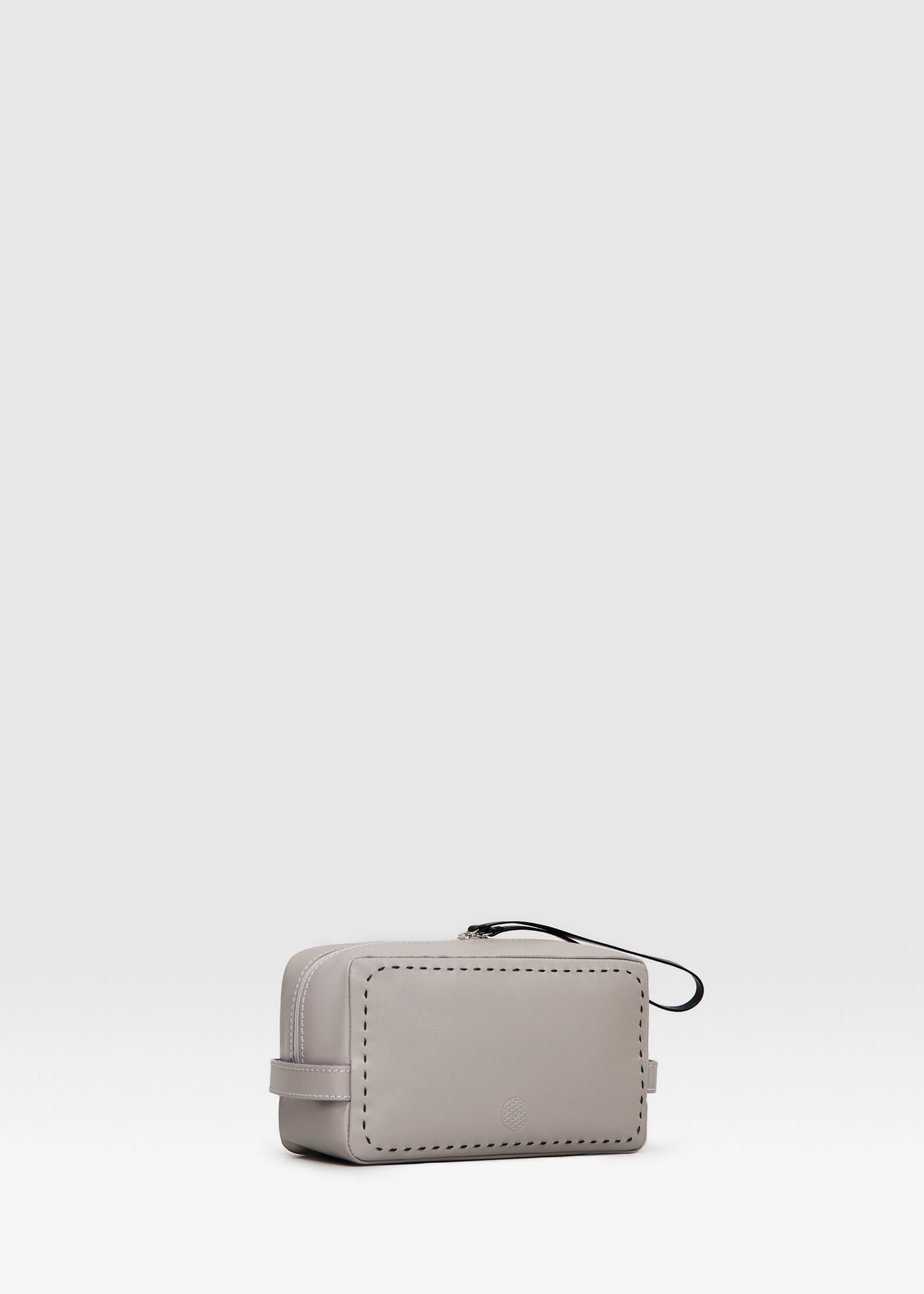 Side view of the Philini Magdalena Pouch in taupe leather, showing short side handles, zip closure with leather pull, and hand-stitched edges. Minimalist small leather pouch, ideal as a travel or makeup bag