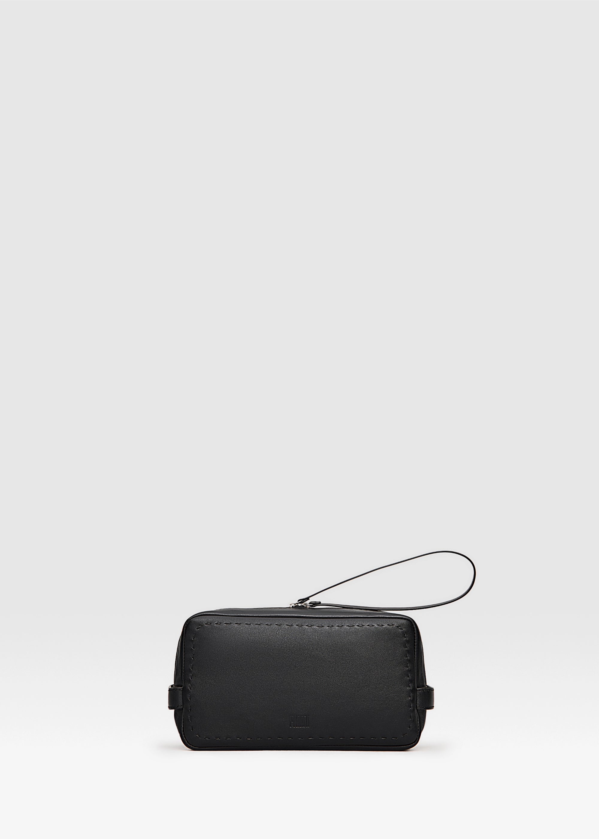 Front view of the Philini Magdalena Pouch in black nappa leather, rectangular silhouette with two short handles, zip closure with leather pull, and hand-stitched edges. Minimalist black makeup pouch