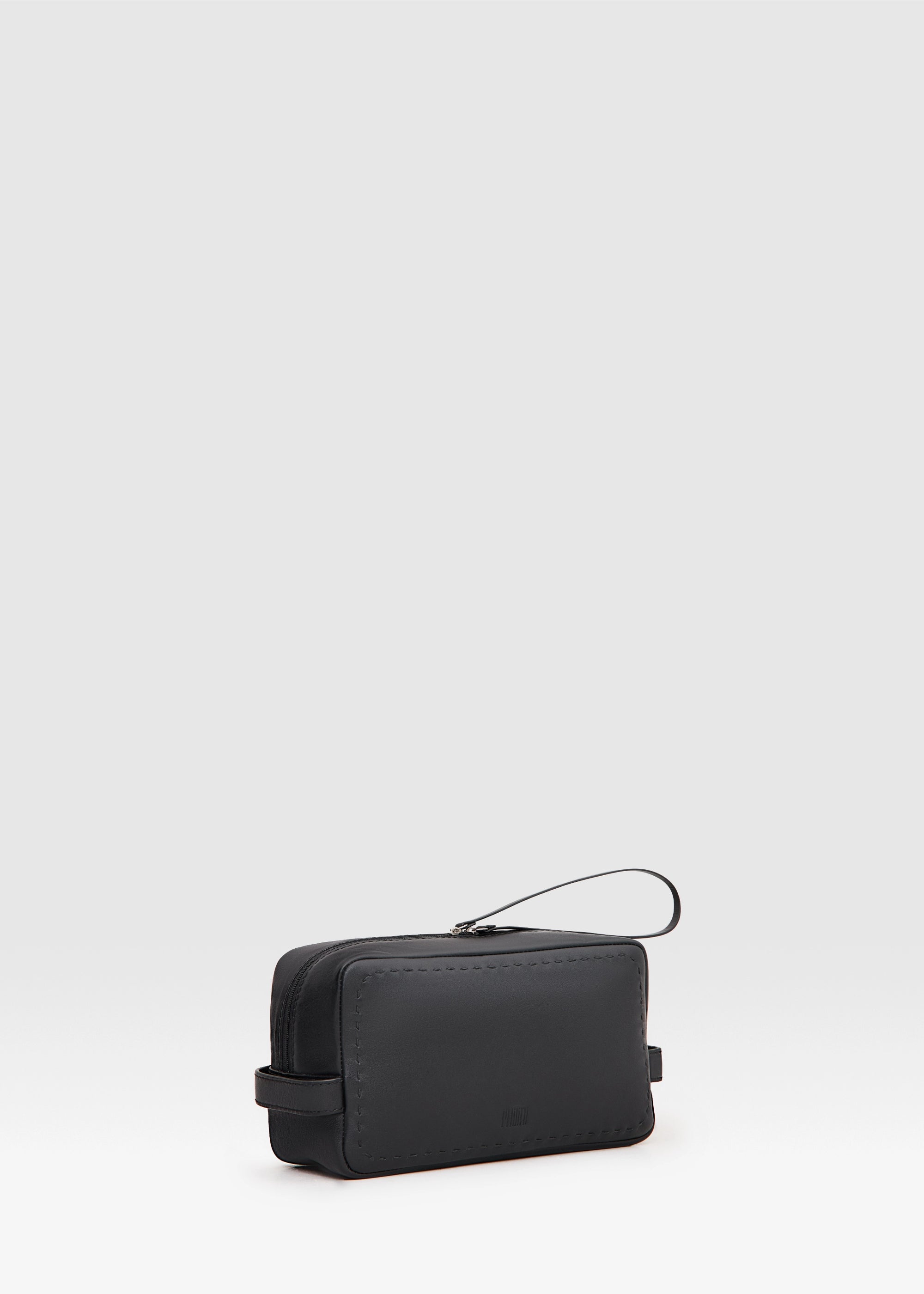 Side view of the Philini Magdalena Pouch in black leather, featuring short side handles, zip closure with leather pull, and hand-stitched edges. Sleek black cosmetic pouch, perfect as an everyday organizer or stylish accessory.