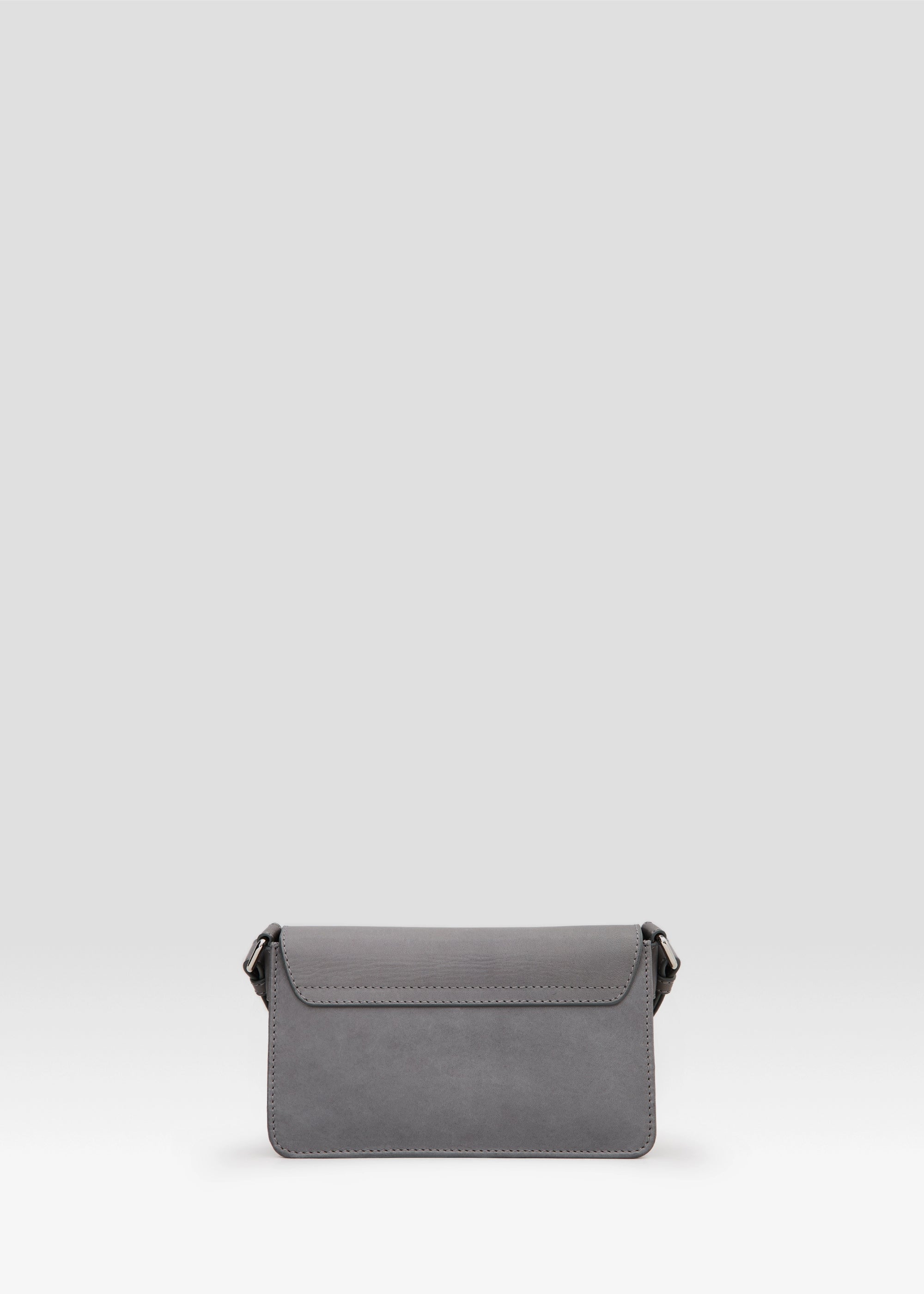 Back view of the Philini Mihaela Wallet Bag in grey nappa leather, highlighting the rectangular profile, secure stitched flap, and adjustable strap with metallic accents. This sleek wallet bag is a functional minimalist accessory.