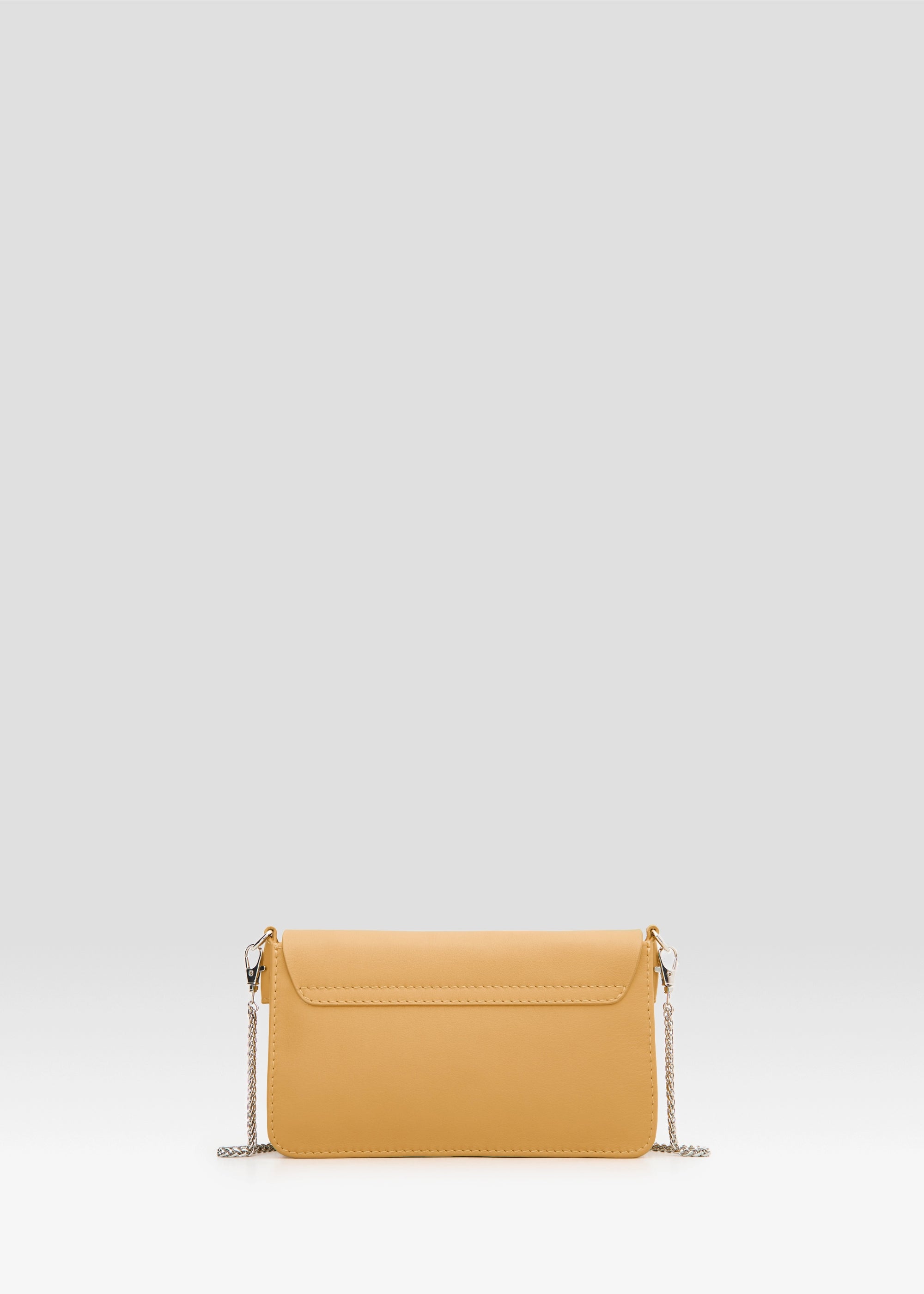 Side view of the Philini Mihaela Wallet Bag in yellow nappa leather, featuring rectangular shape, a front flap with silver cufflink closure, accordion sides, and a long metal chain handle. Compact, refined wallet bag for women, featuring minimalist design and crafted for conscious luxury style.