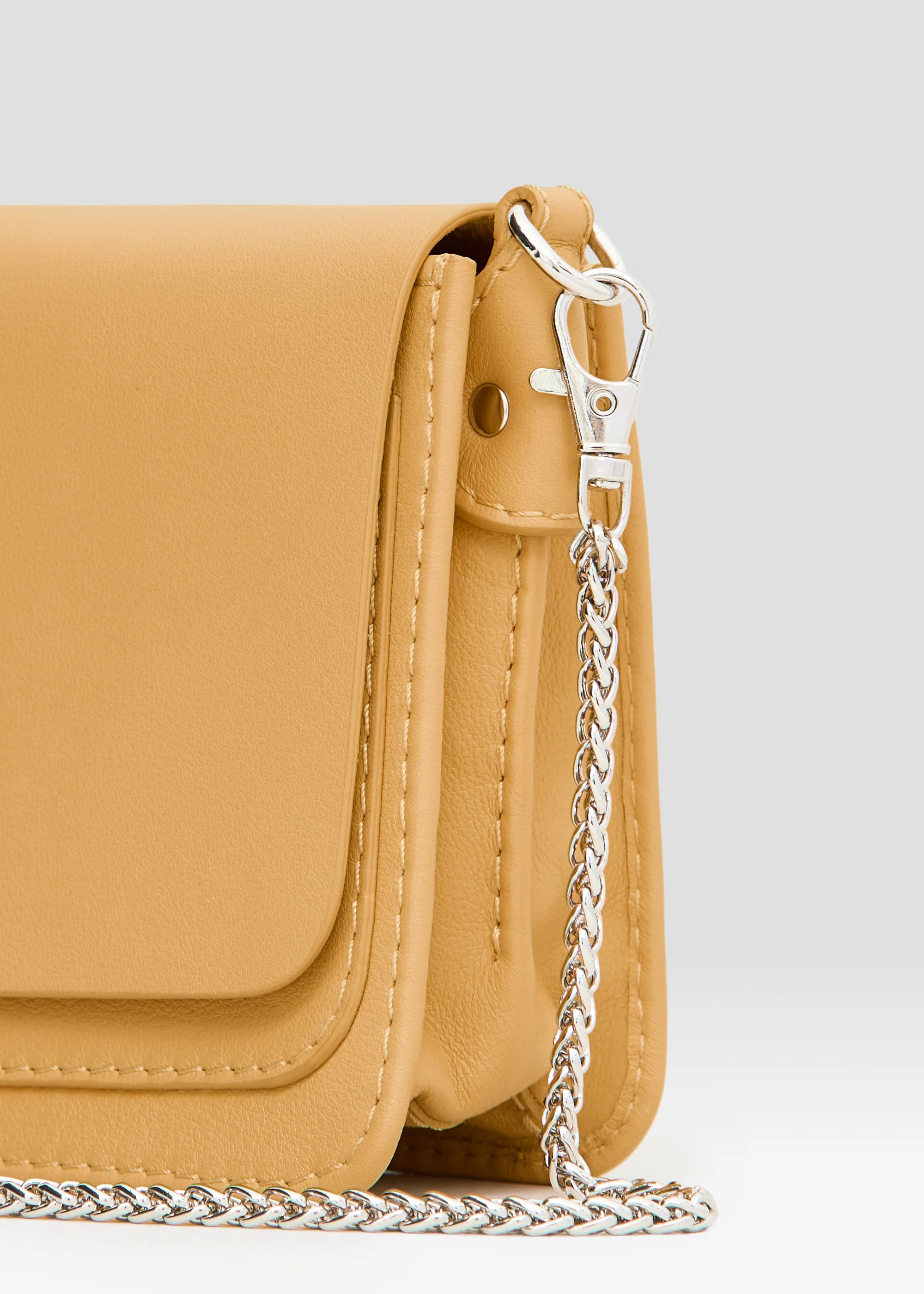  Back view of the handcrafted yellow Philini Mihaela Wallet Bag in nappa leather with stitched flap, silver chain strap, and tapered shape. A compact luxury designer accessory