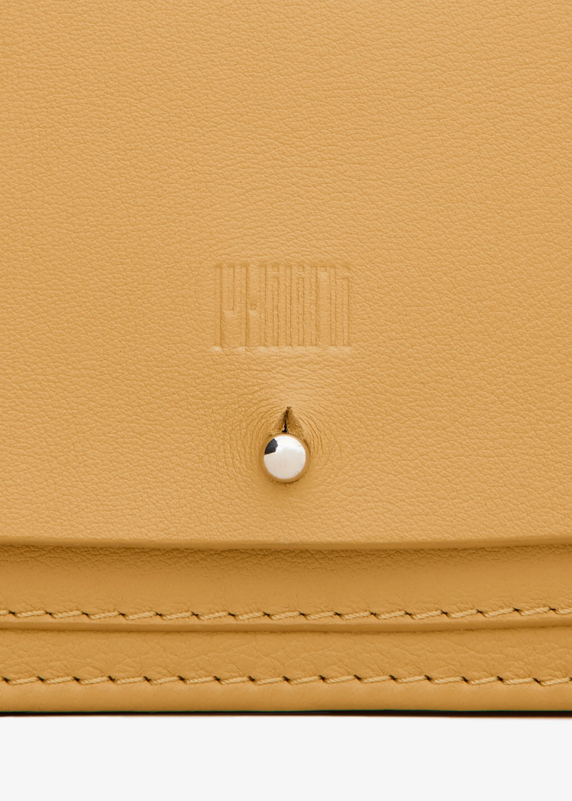 Detailed view of the handcrafted yellow Philini Mihaela Wallet Bag in nappa leather with stitched flap, silver chain strap, and tapered shape. A compact luxury designer accessory