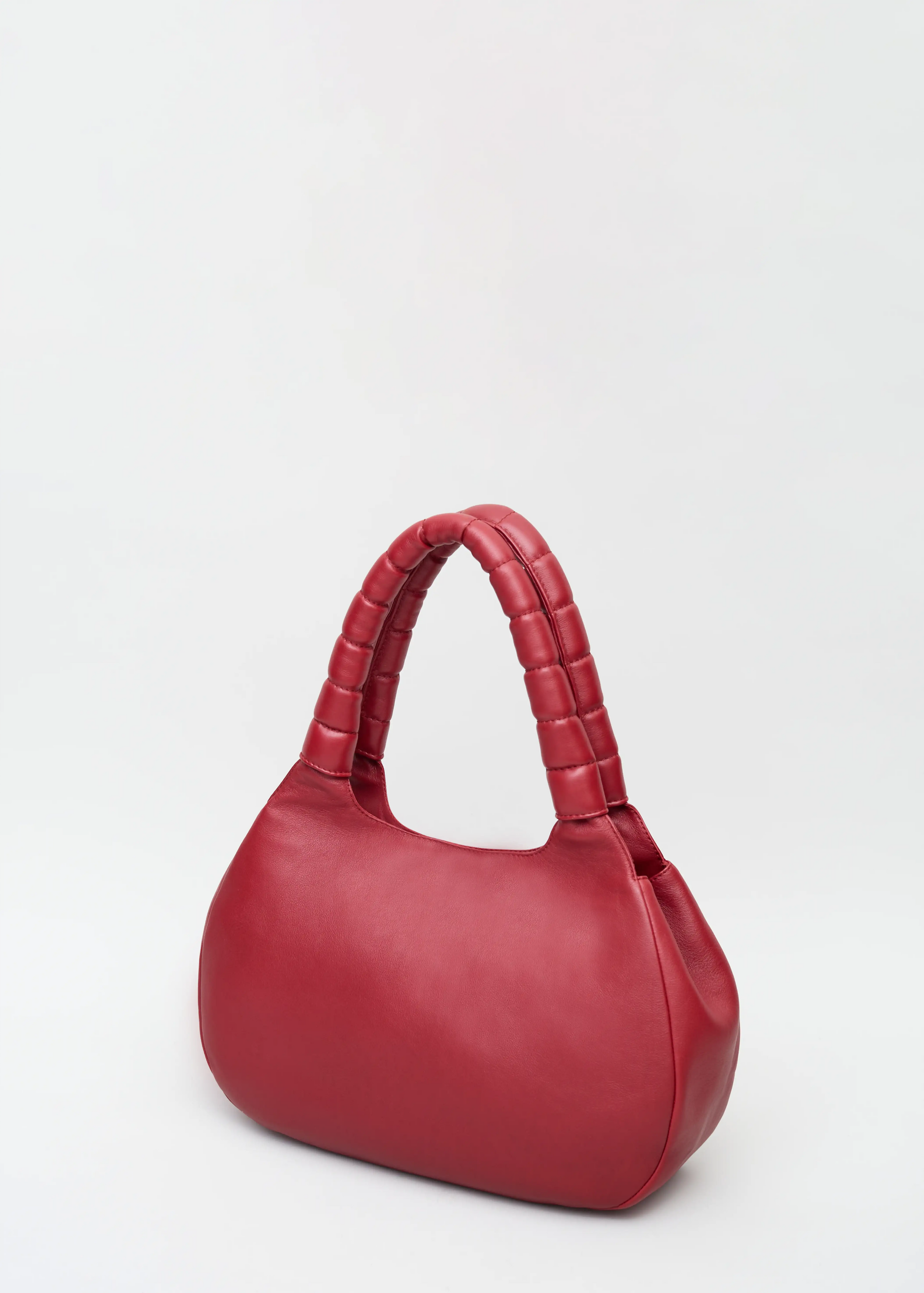 Side view of the Philini Adreann Hobo Bag in red nappa leather, featuring two integrated soft handles and a stamped logo. Soft leather hobo tote, premium minimalist purse