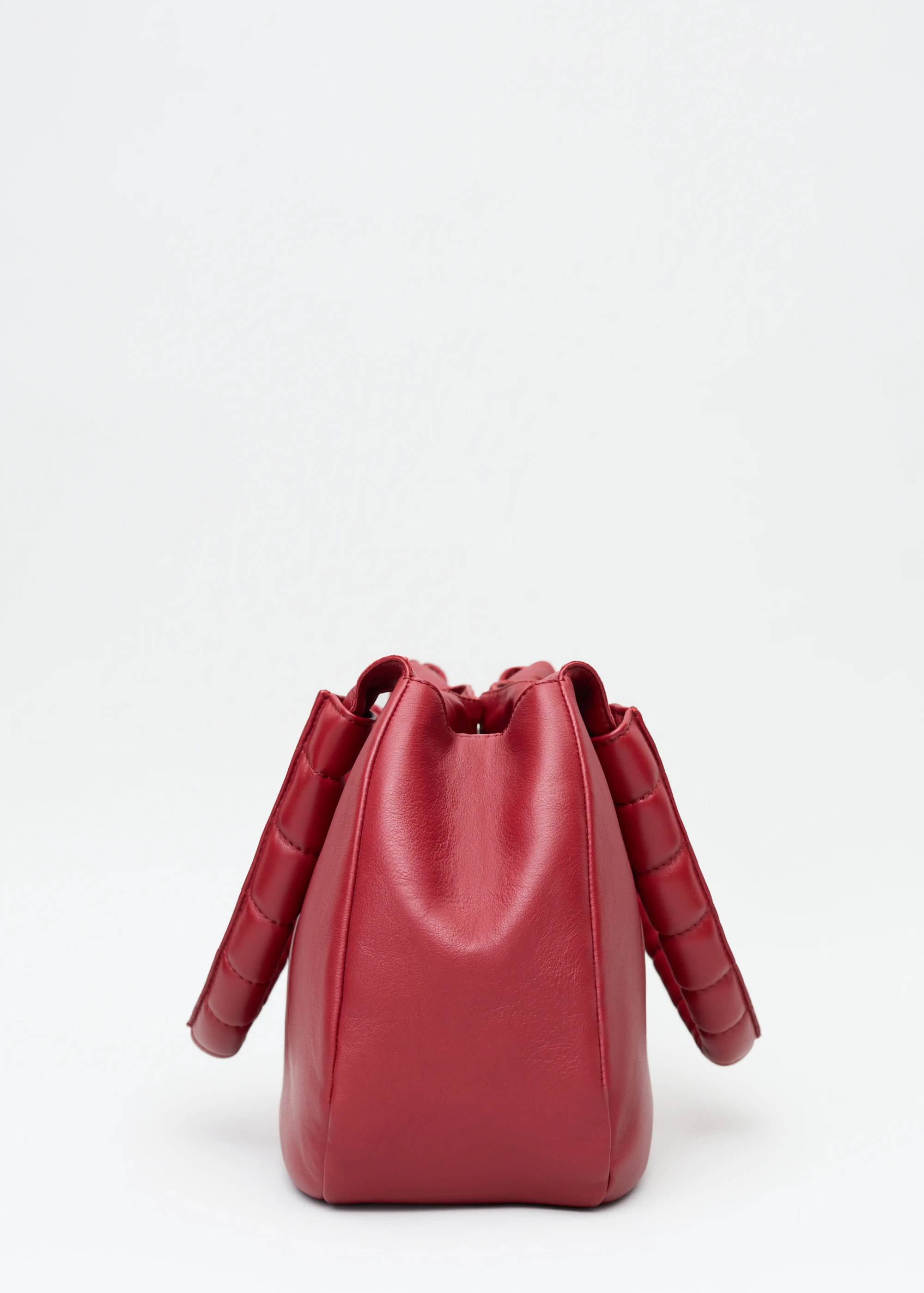 Side view of the Philini Adreann Hobo Bag in red nappa leather, featuring two integrated soft handles. High-quality soft leather hobo tote