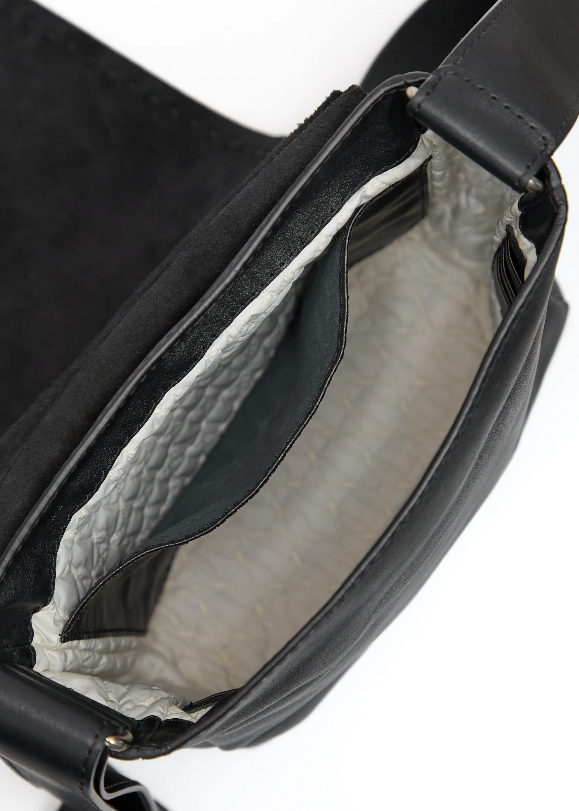 Inside view of the Philini Anastasia Messenger Bag in black aniline nappa leather, featuring hand-stitched details, a large open back pocket, and washable vanilla lining. Thoughtfully crafted leather crossbody bag offering  timeless everyday elegance