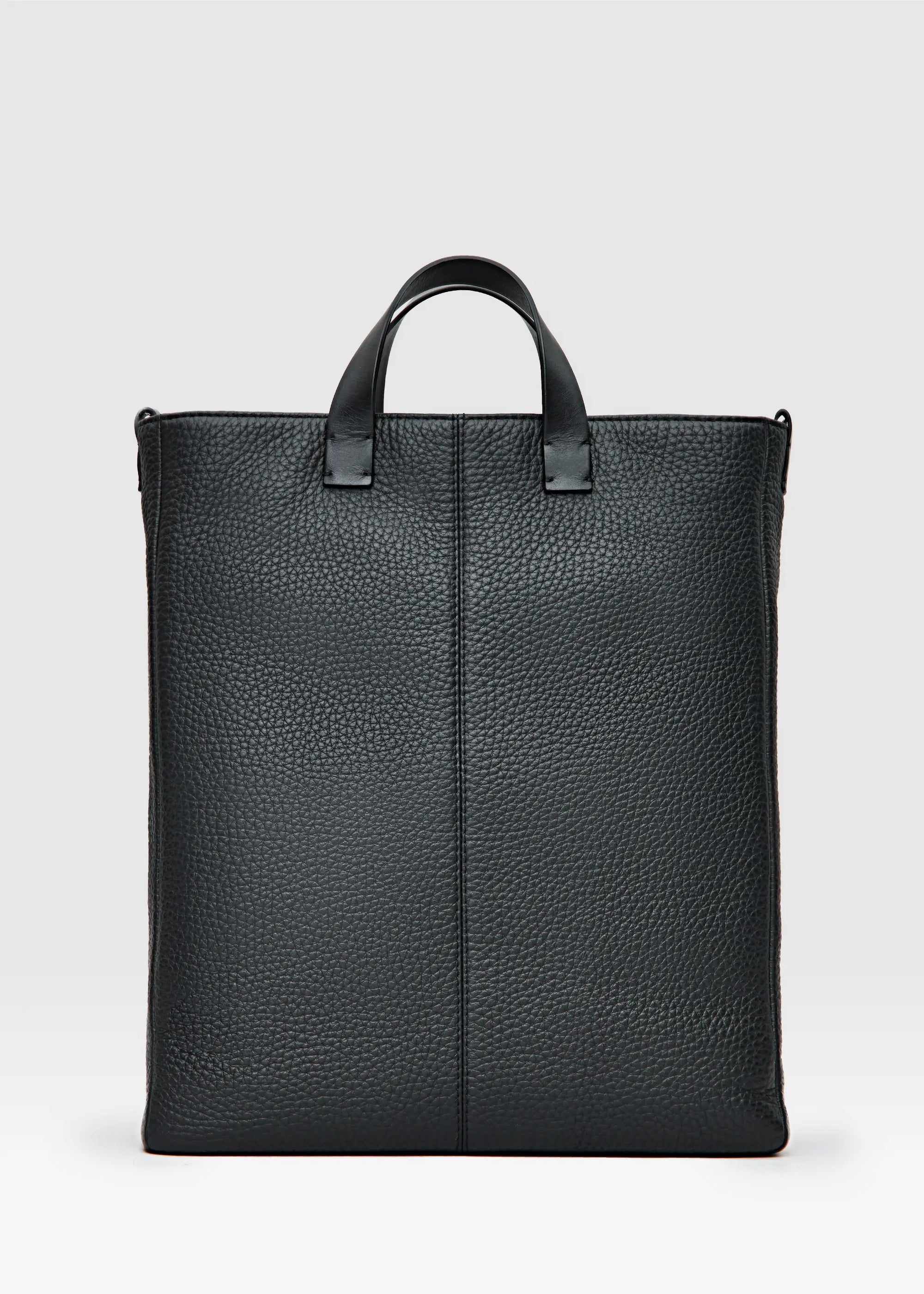 Philini Andrea handcrafted black leather tote bag with a minimalist and elegant design, featuring premium full-grain European leather, durable top handles, and an adjustable shoulder strap. Ethically made-to-order by skilled artisans in small batches, this sustainable tote is perfect for modern women seeking timeless style and functionality. Available exclusively on Philini.com.