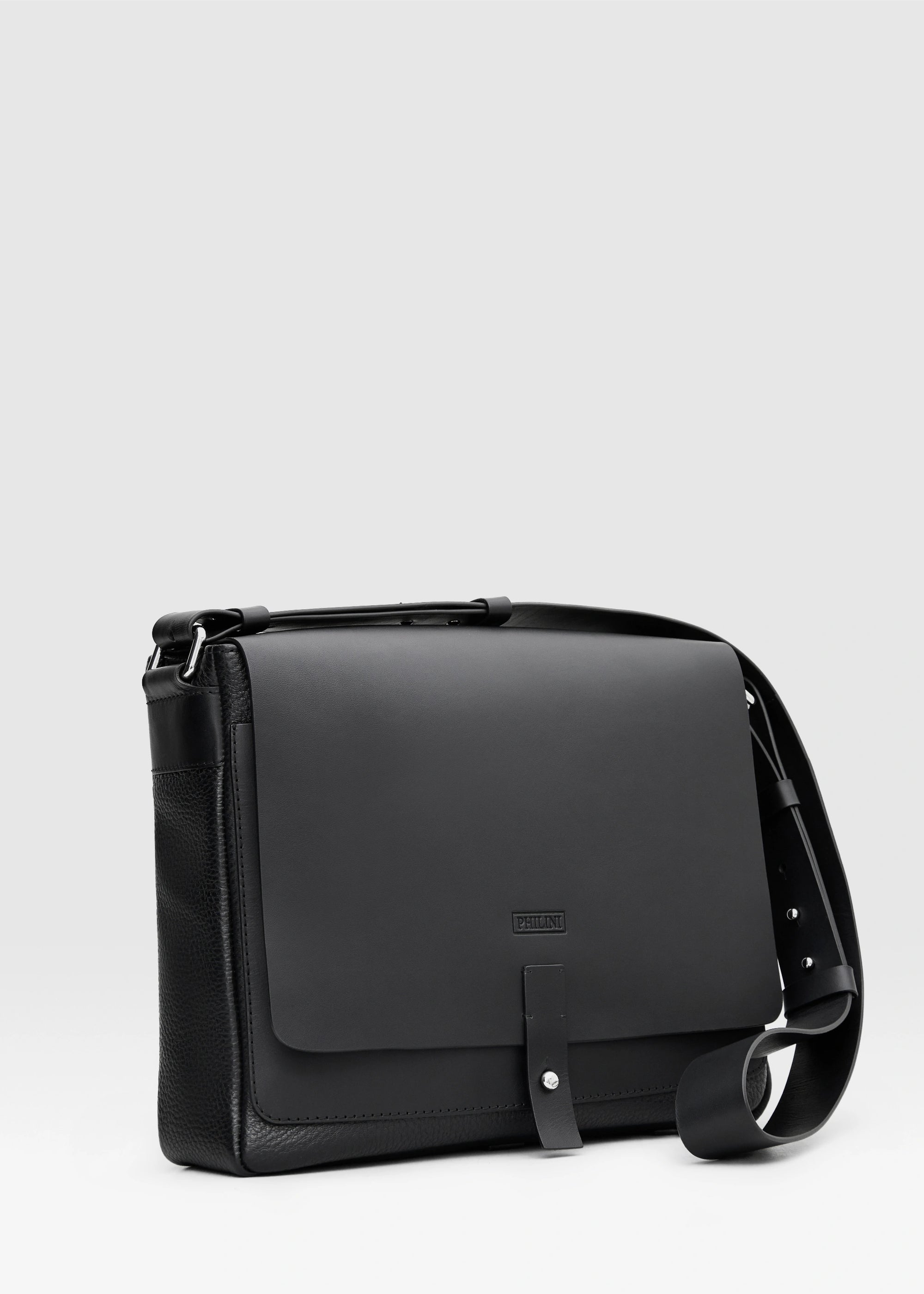 Angled view of a handcrafted luxury leather handbag Aneta in black made from full-grain premium leather sourced from Europe. This elegant and durable design combines timeless aesthetics with sustainable craftsmanship, ideal for women seeking exclusive and versatile fashion accessories.