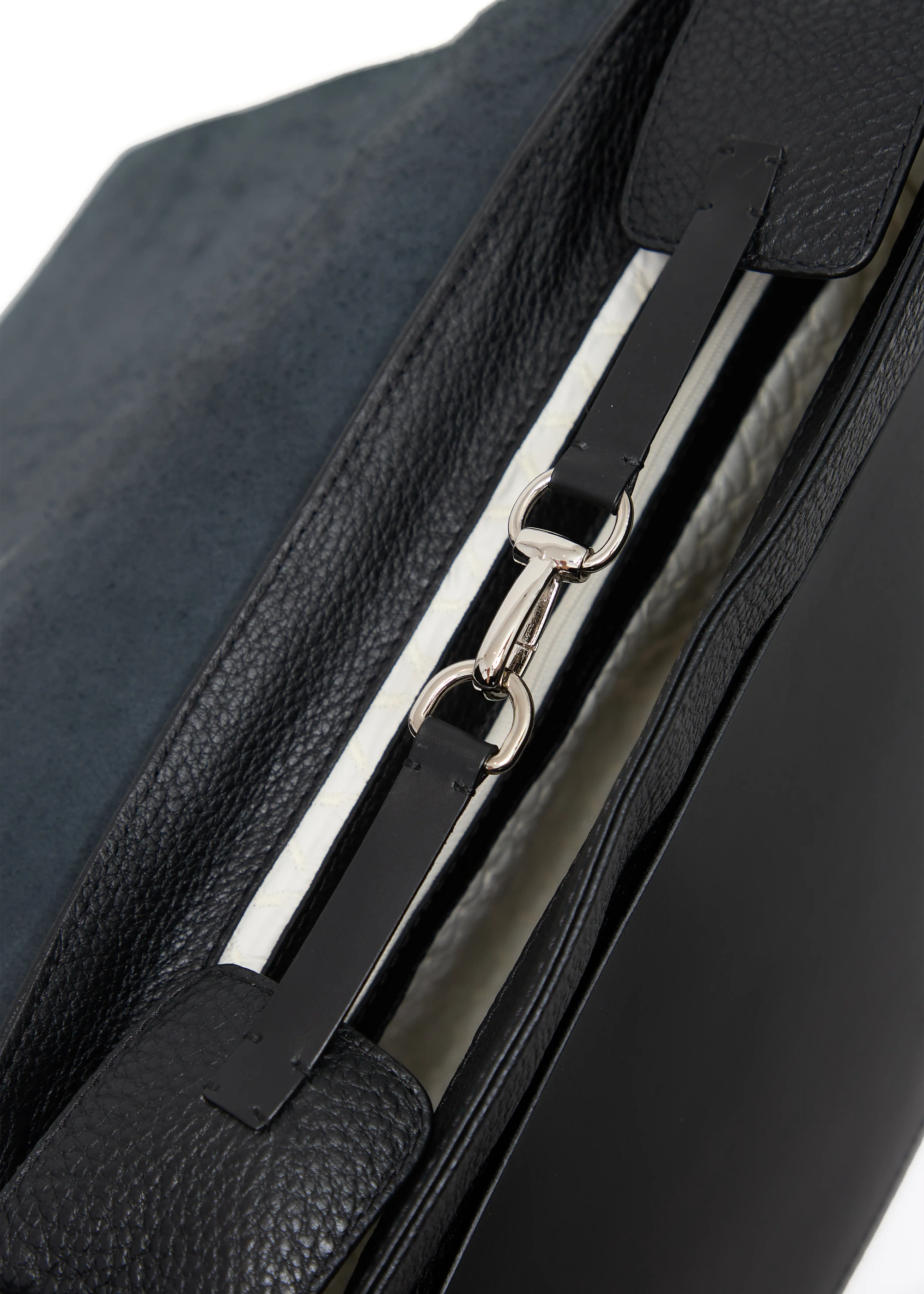 Close-up of the Philini Aneta Bag clasp, featuring a silver carabiner and leather shaping plates with silver details securing the bag&#39;s opening