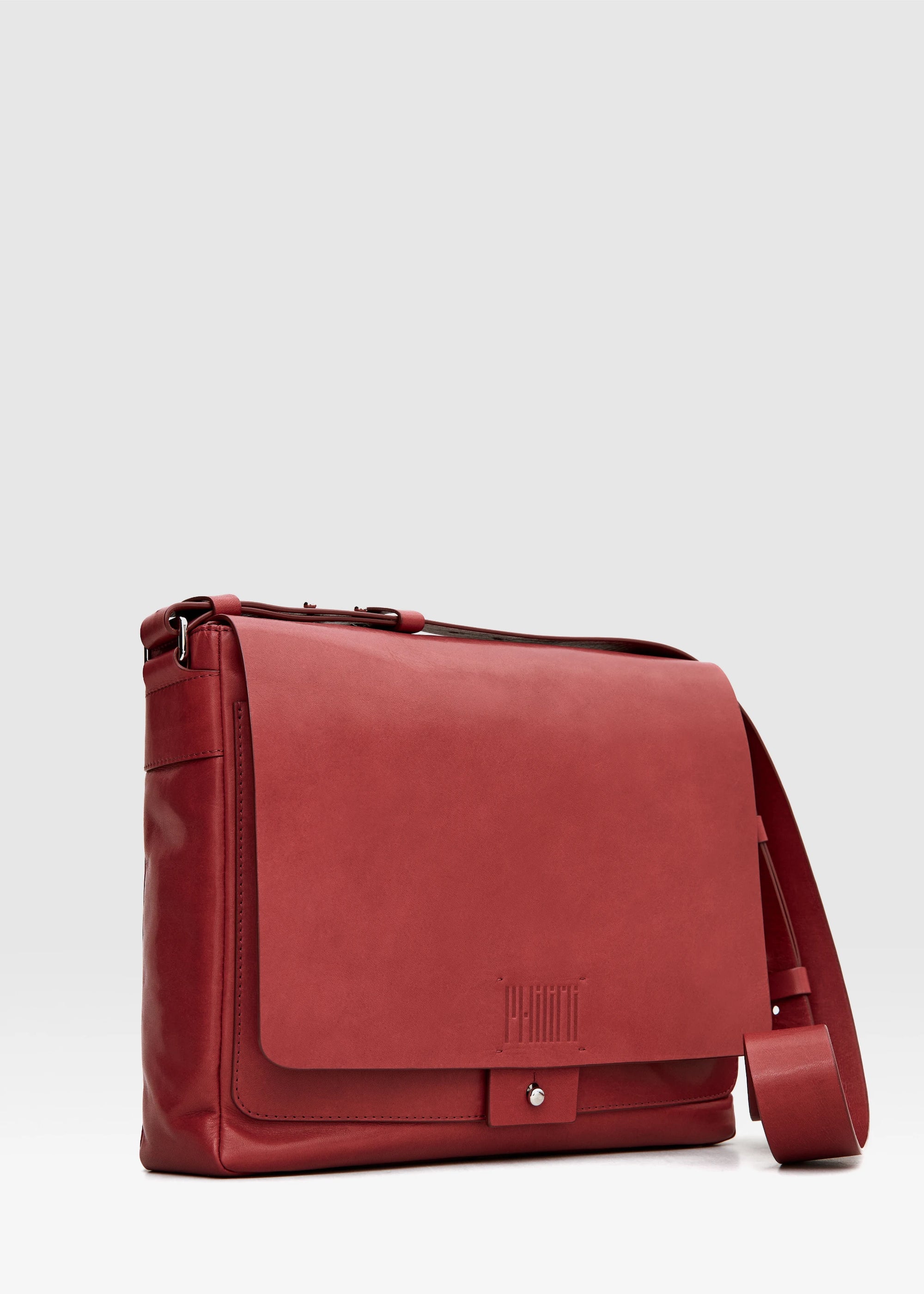 Angled view of the Philini Aneta Bag in Red, featuring a large rectangular shape, an adjustable leather strap, and silver-colored accents crafted from natural red aniline leather