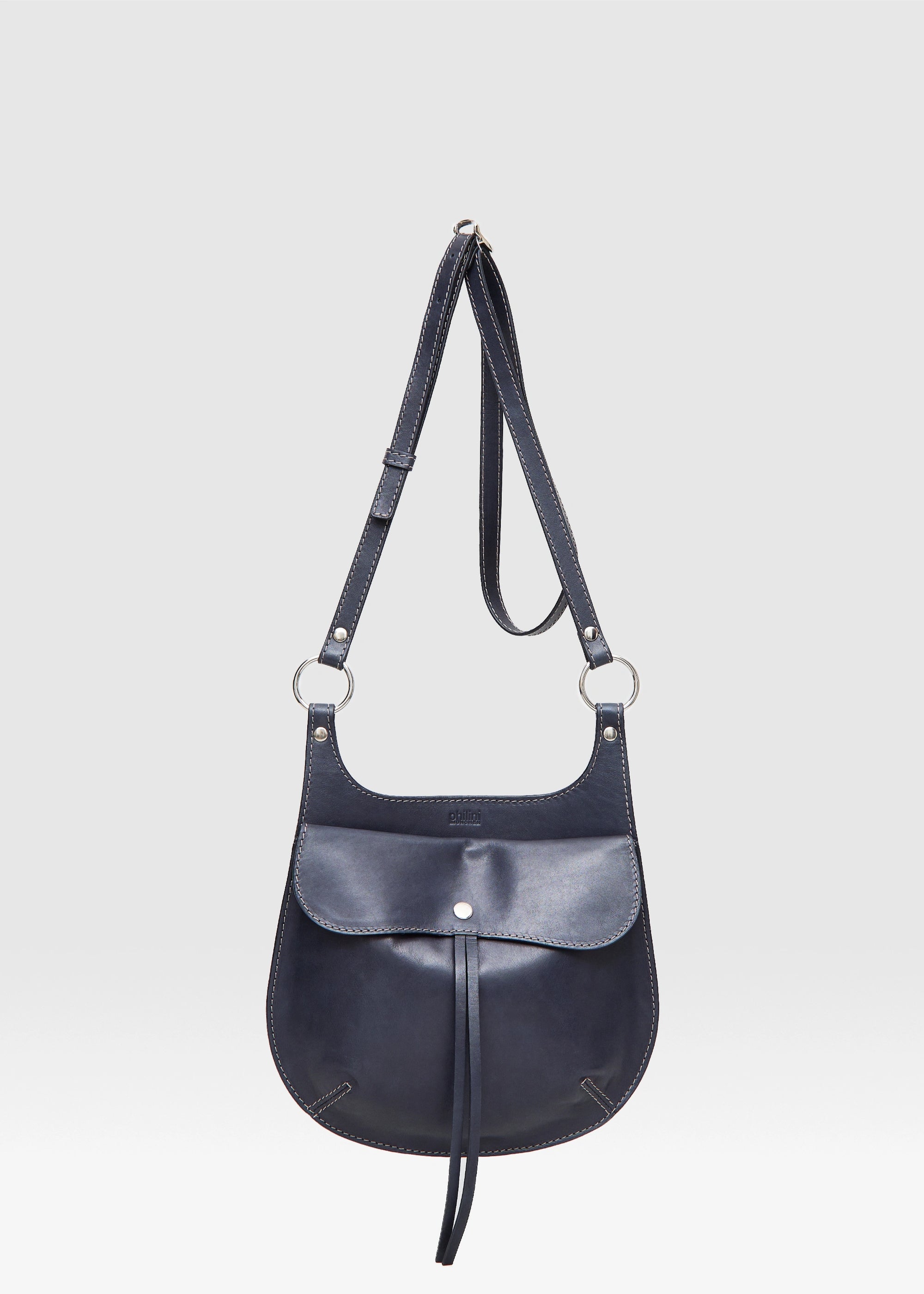 Front view of the Philini Cowboy Black Crossbody Saddle Bag in calf leather with rounded silhouette, snap closure, and adjustable strap