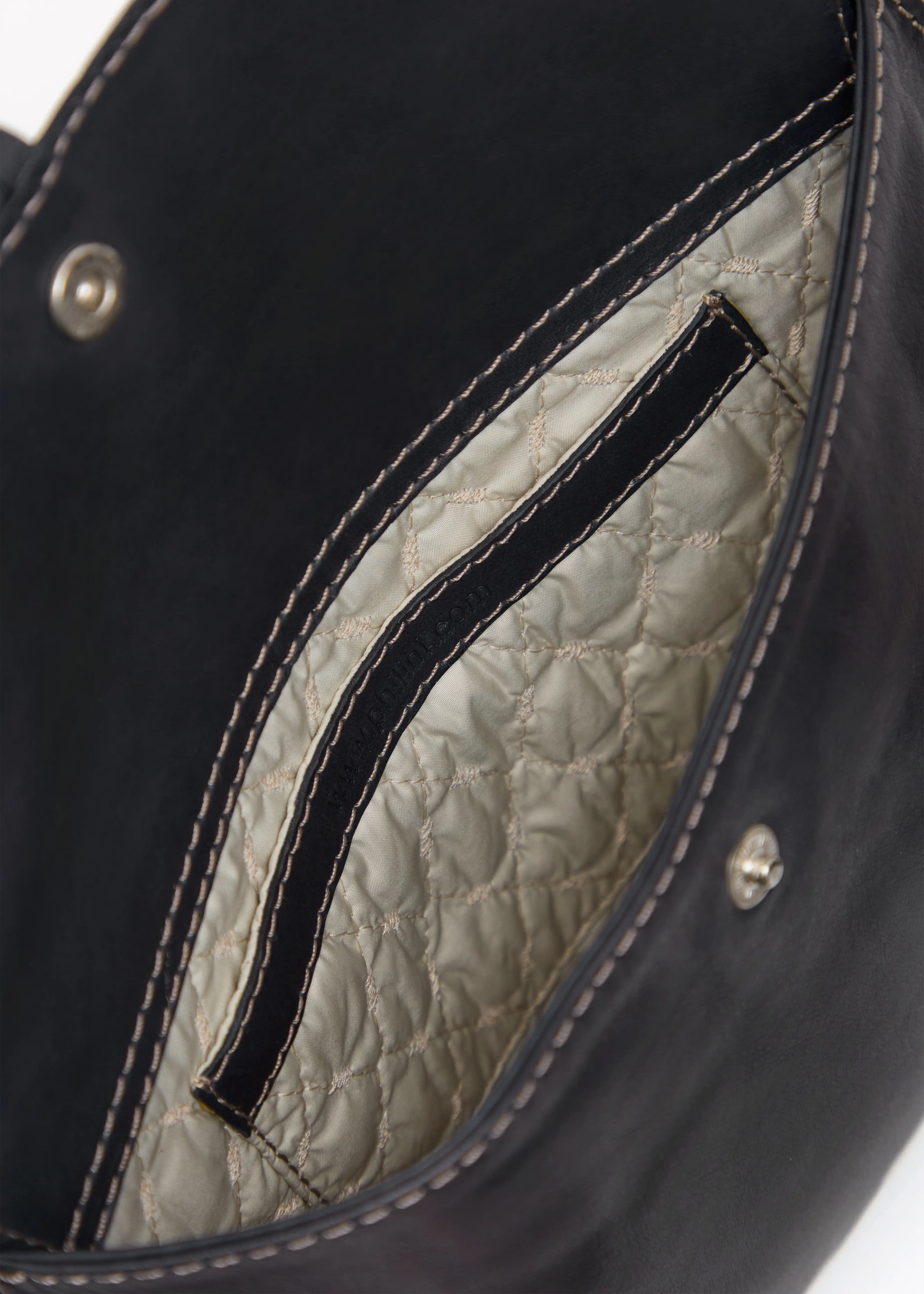 Inside view of the Philini Cowboy Crossbody Bag in black calf leather, showing stitched vanilla lining, small interior pocket, and push-button closure