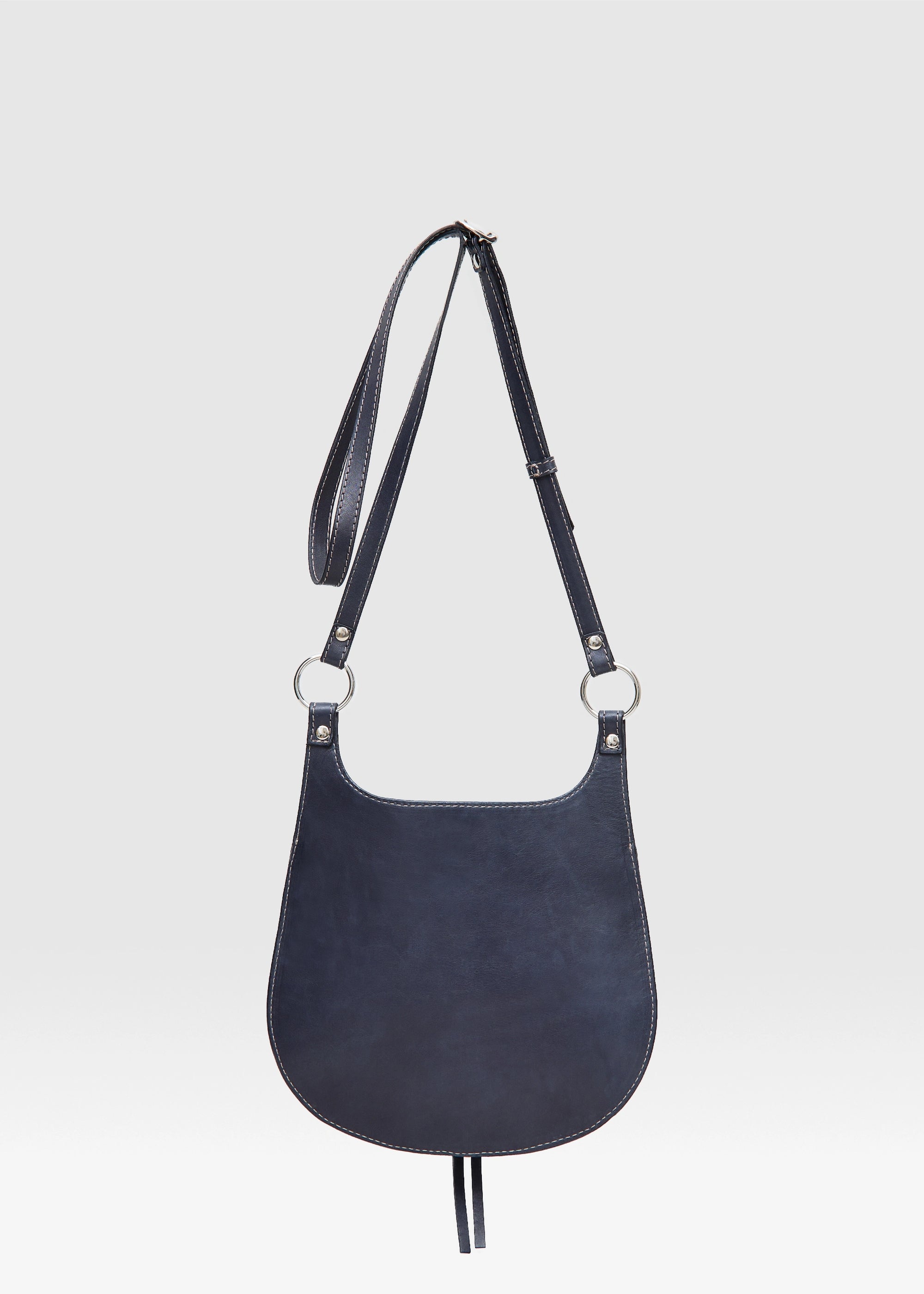 Back view of the Philini Cowboy Crossbody Bag in black calf leather, rounded saddle silhouette with flat back and long adjustable strap. Ethical handcrafted mini shoulder bag