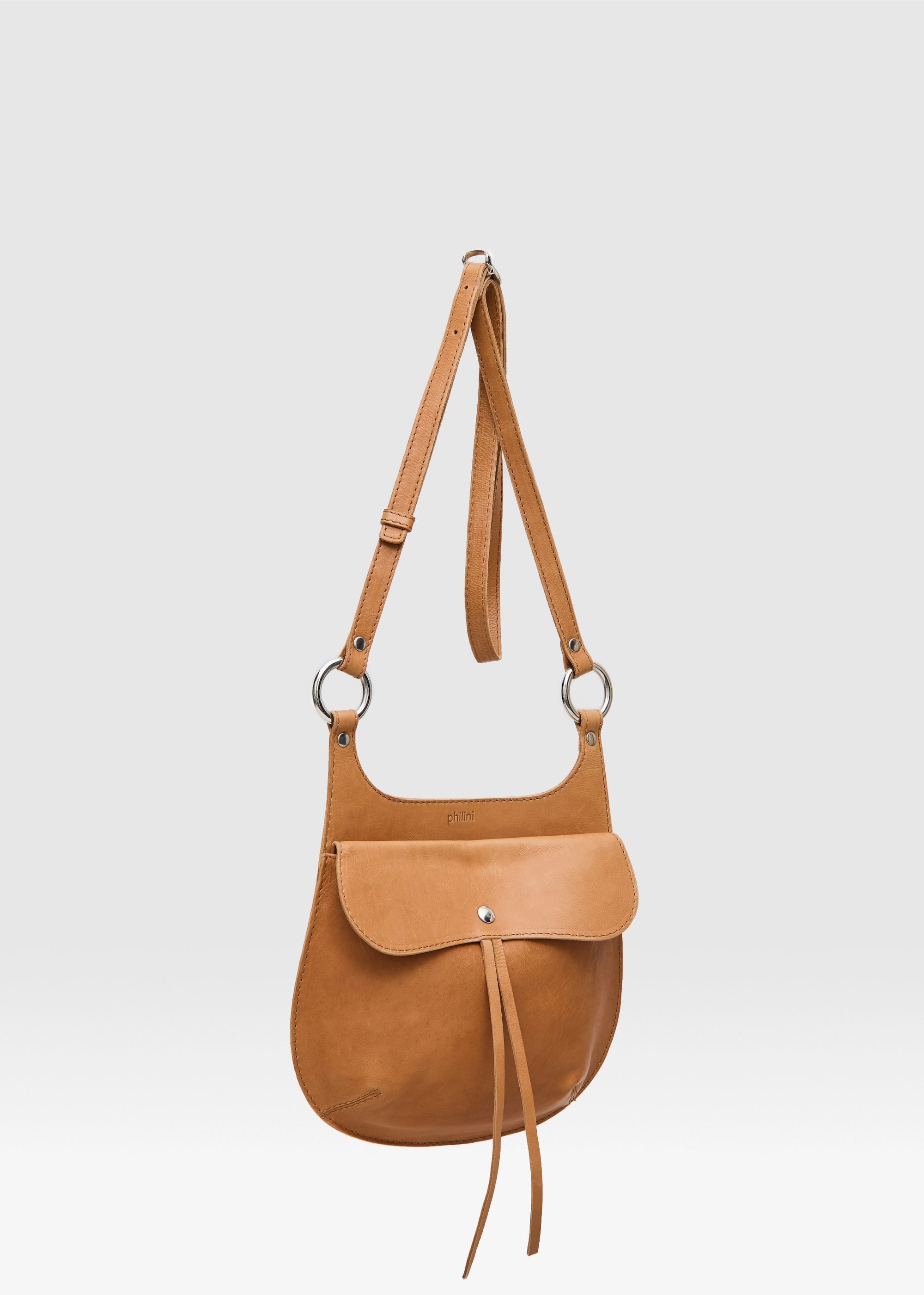 Side view of the Philini Cowboy Crossbody Bag in cognac calf leather, curved shape with front flap  