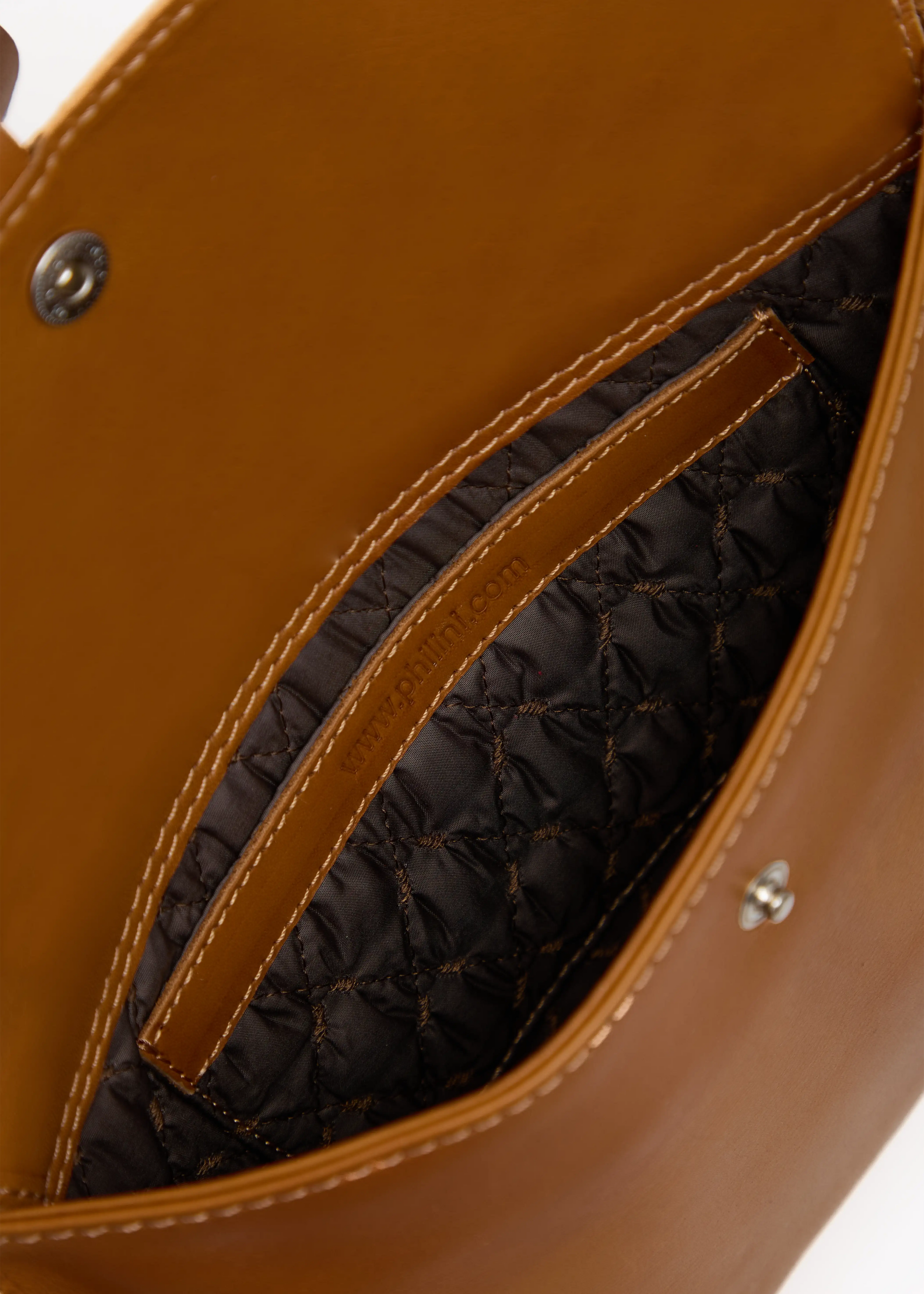 Inside view of the Philini Cowboy Crossbody Bag in cognac calf leather, open flap revealing stitched brown lining, inner pocket, and secure push-button closure