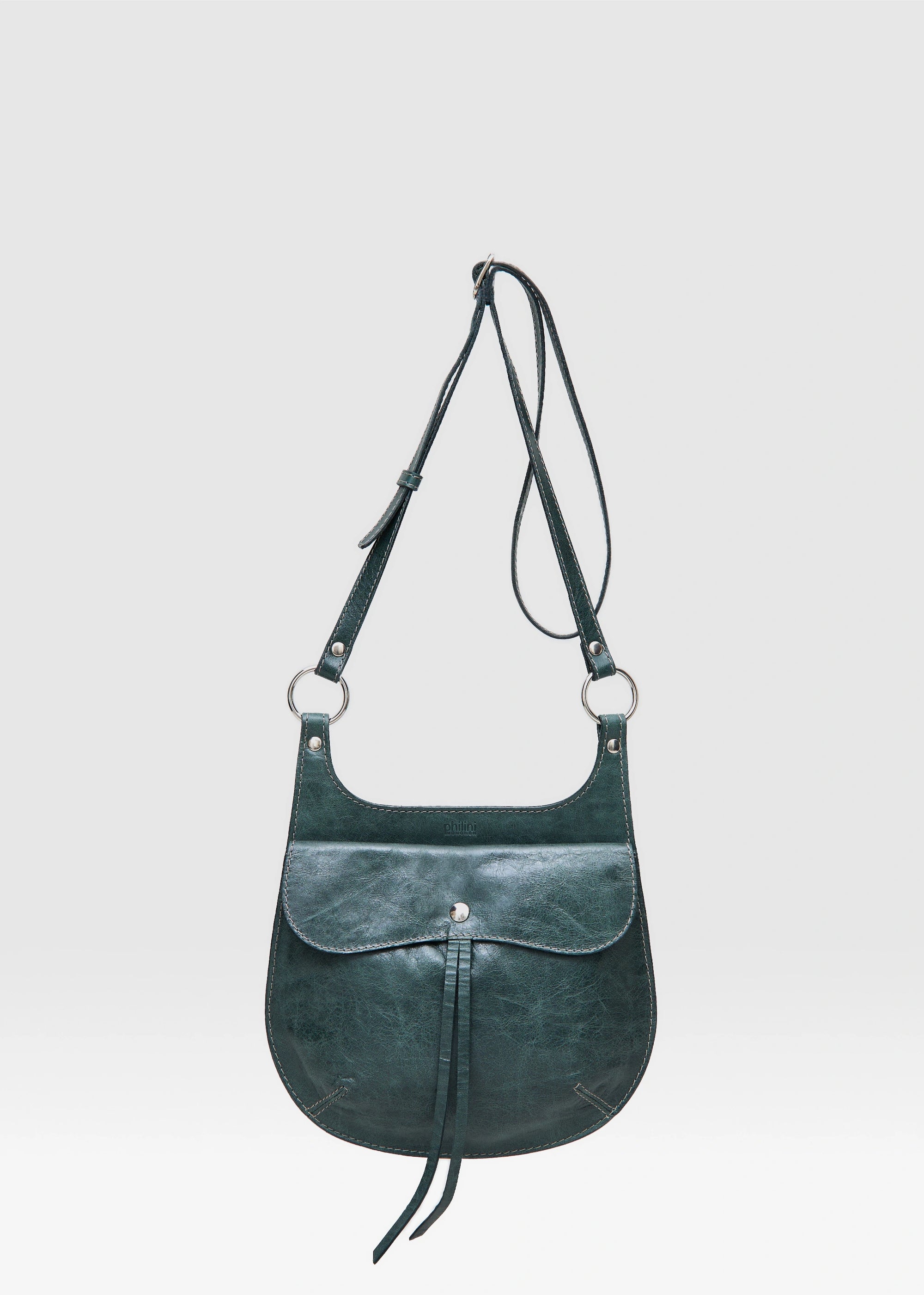 Front view of the Philini Cowboy Crossbody Bag in dark green calf leather, rounded saddle silhouette with front flap, snap closure, and long adjustable strap. Elegant mini leather crossbody bag