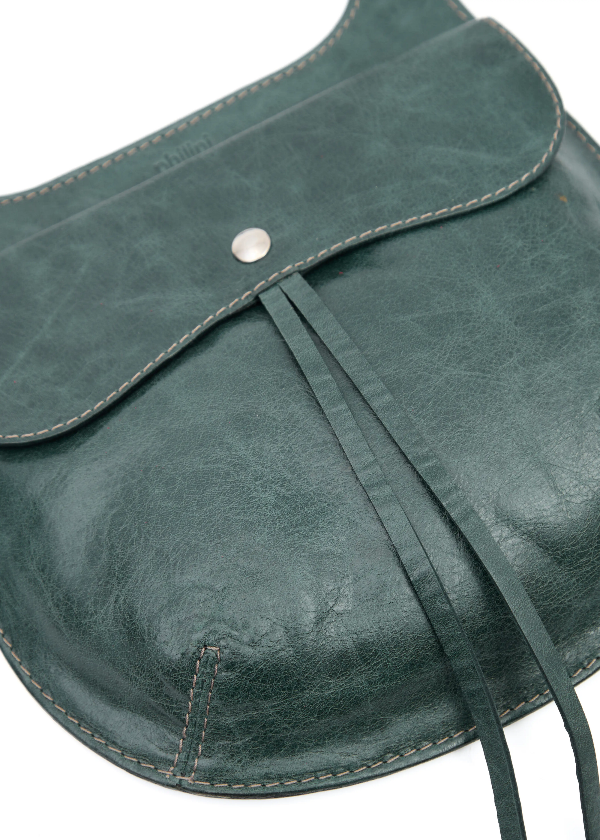 Close-up of the Philini Cowboy Crossbody Bag in dark green calf leather, featuring the front flap with snap button and debossed logo. Sustainable minimal handbag made of premium leather.