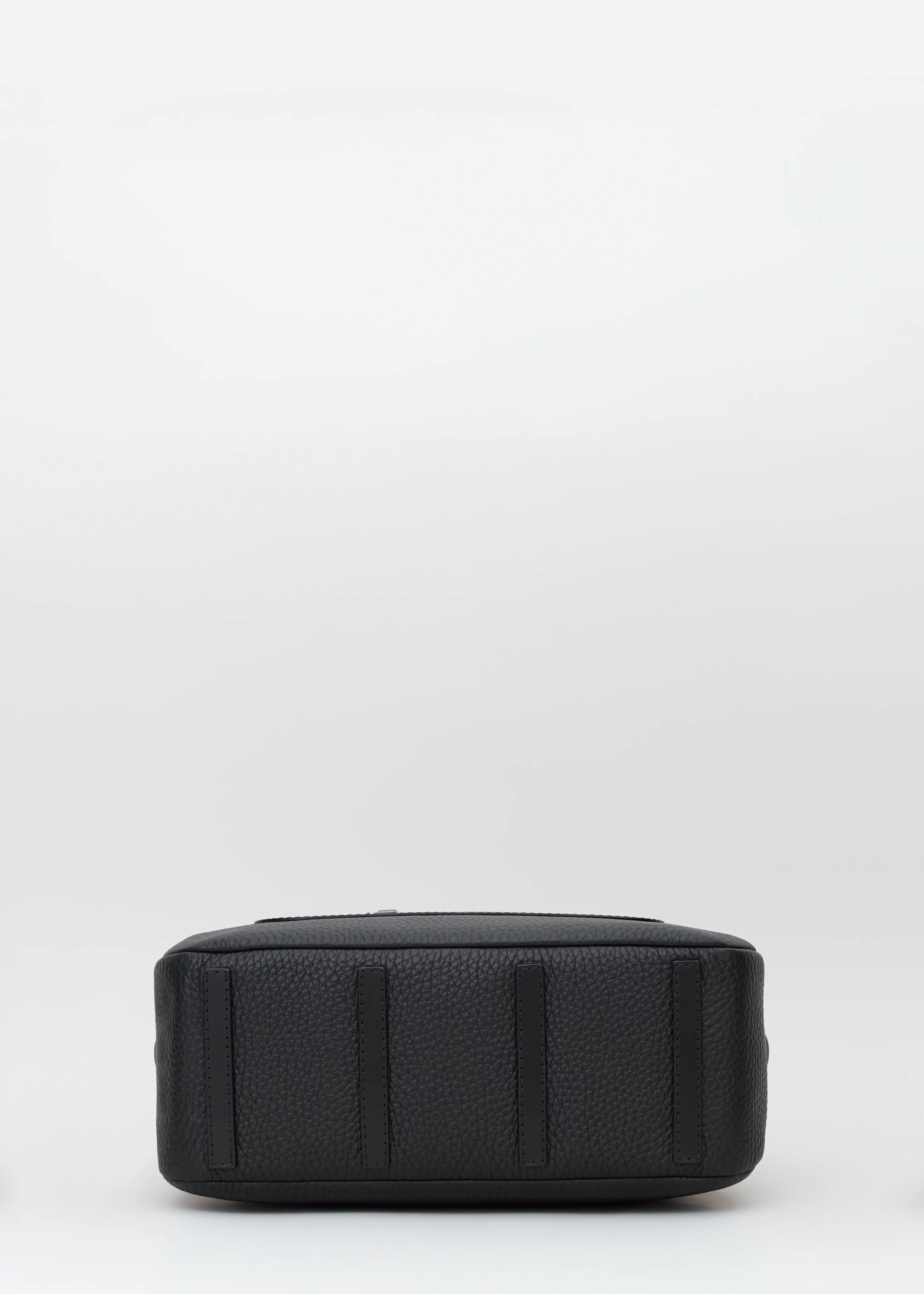Bottom view of the Philini Domi Black Dome Handbag, crafted from black buffalo leather with four small leather pads as protective feet. The minimalist luxury accessory.