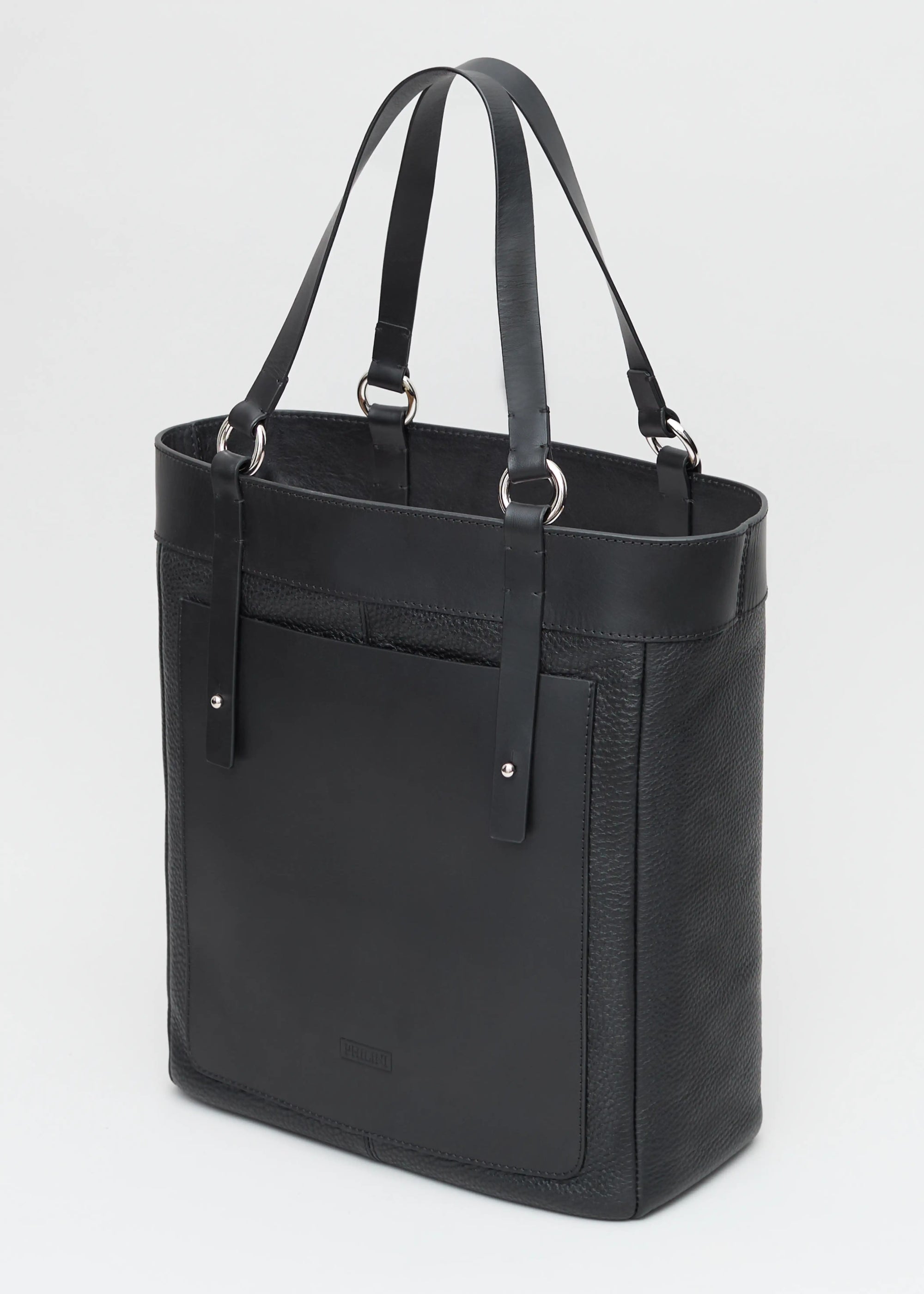 Side view of Philini Elena Black Tote Bag in two types of genuine leather, a full-grain leather exterior pocket and silver details on the sturdy handles. This timeless and eco-friendly bag is perfect for modern women seeking elegance and functionality.