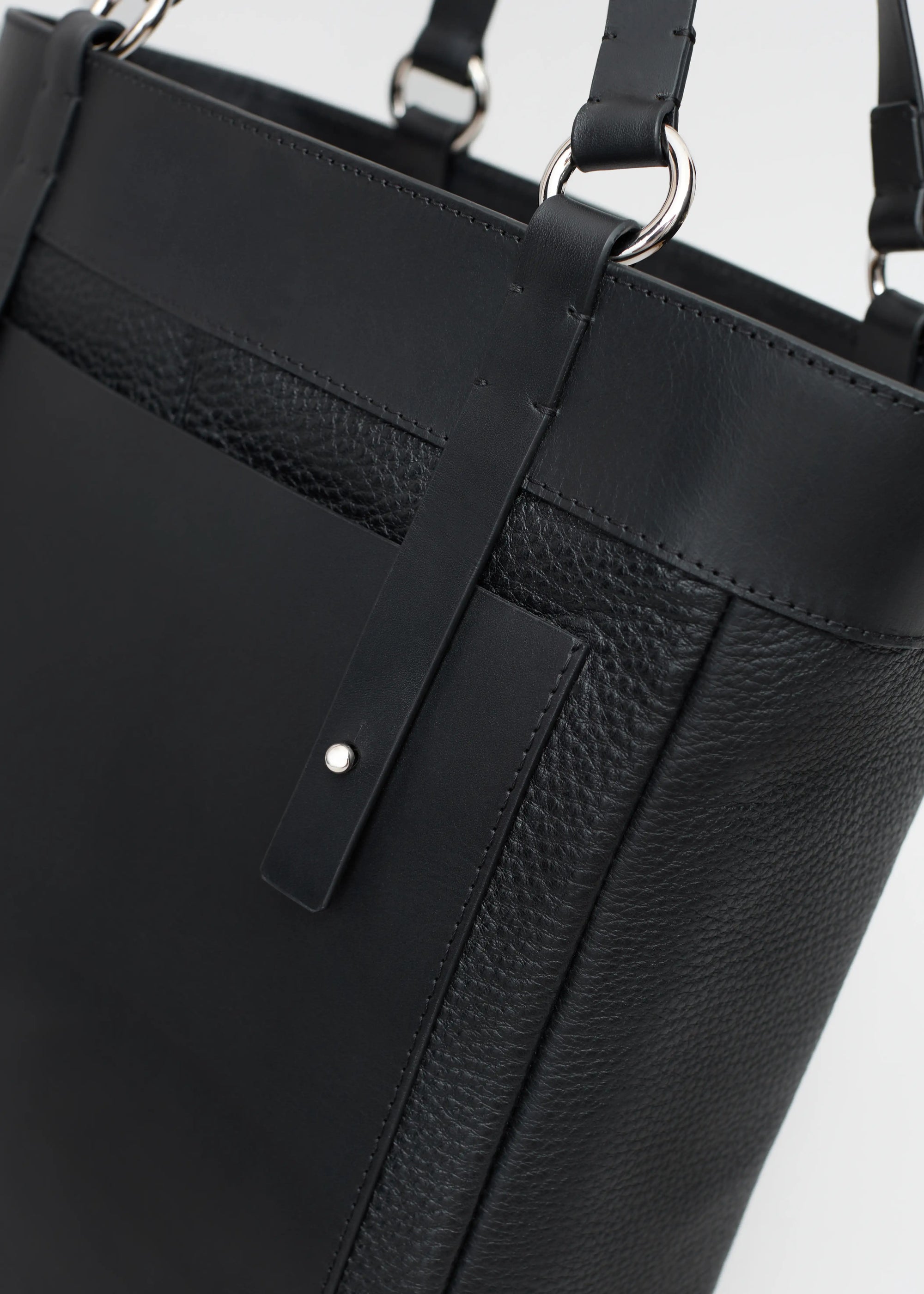 Detailed view of the Philini Elena Black Tote Bag, showing a magnetic closure and a deep zippered pocket in the lining, crafted with premium leather and functional design.