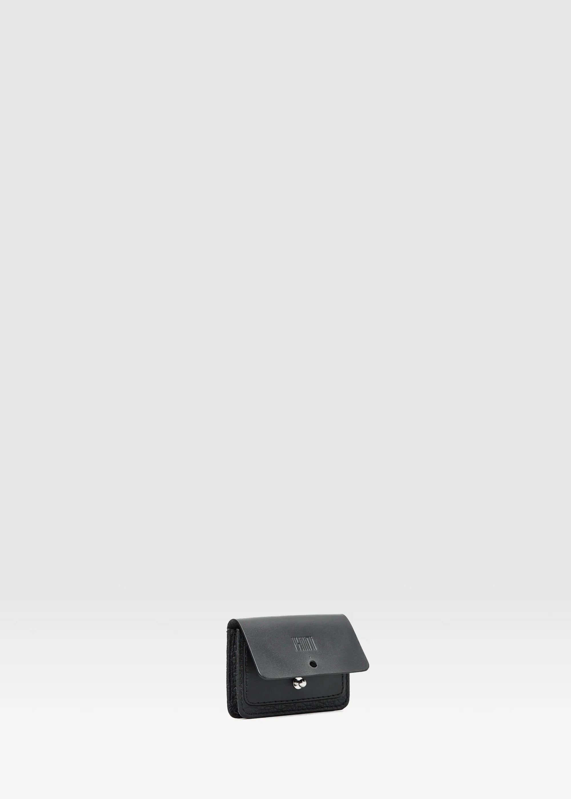 Front-up view of the Philini Lea Black Business Card Holder with the flap open, showing a silver cufflink closure and small exterior pocket. Crafted from natural leather, this minimalist cardholder is handcrafted leather business accessory 