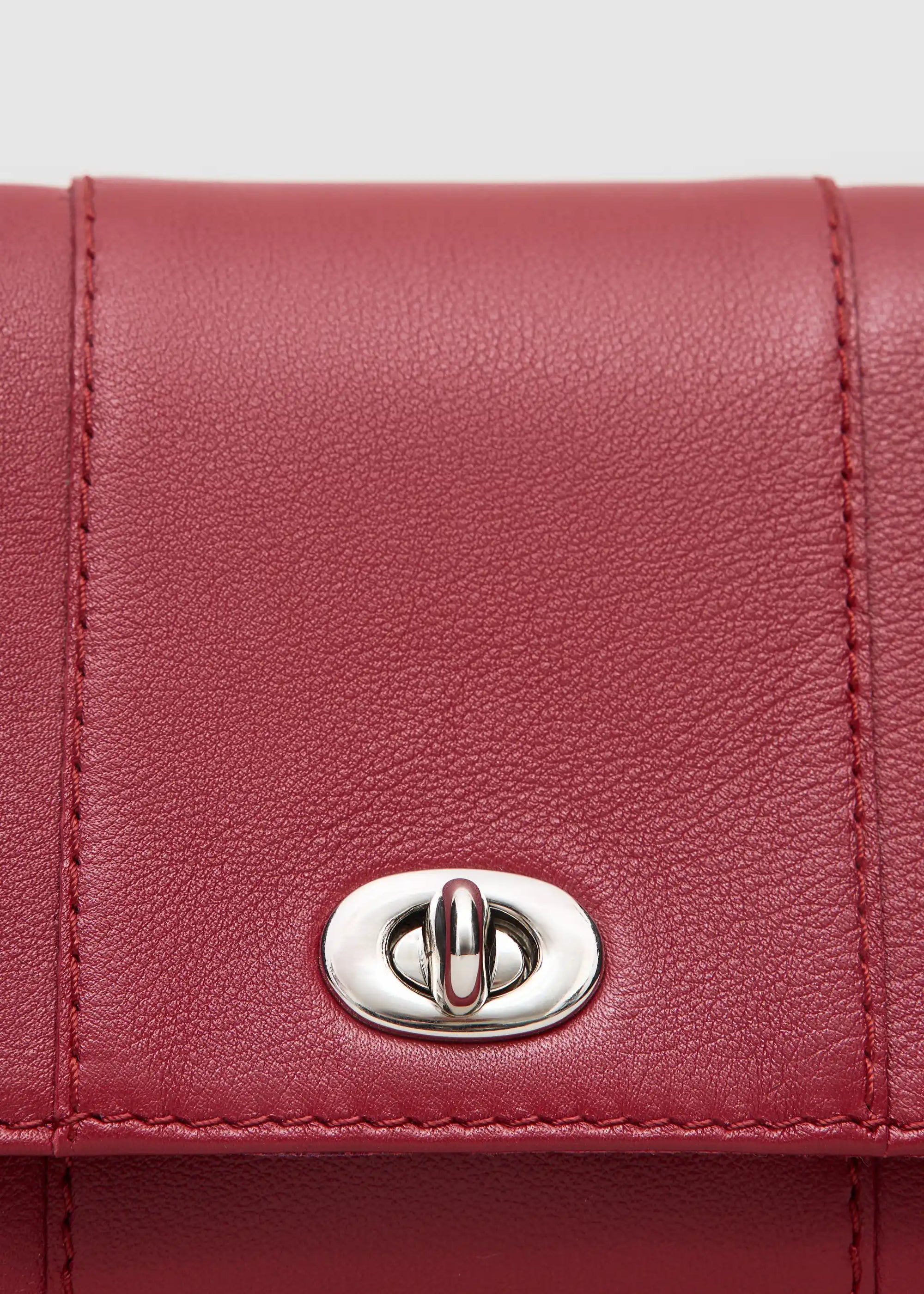 Close front view of the Philini Marina Mini Crossbody Bag in red nappa leather, showing front flap with silver clasp, silver chain. Compact red leather crossbody bag. 