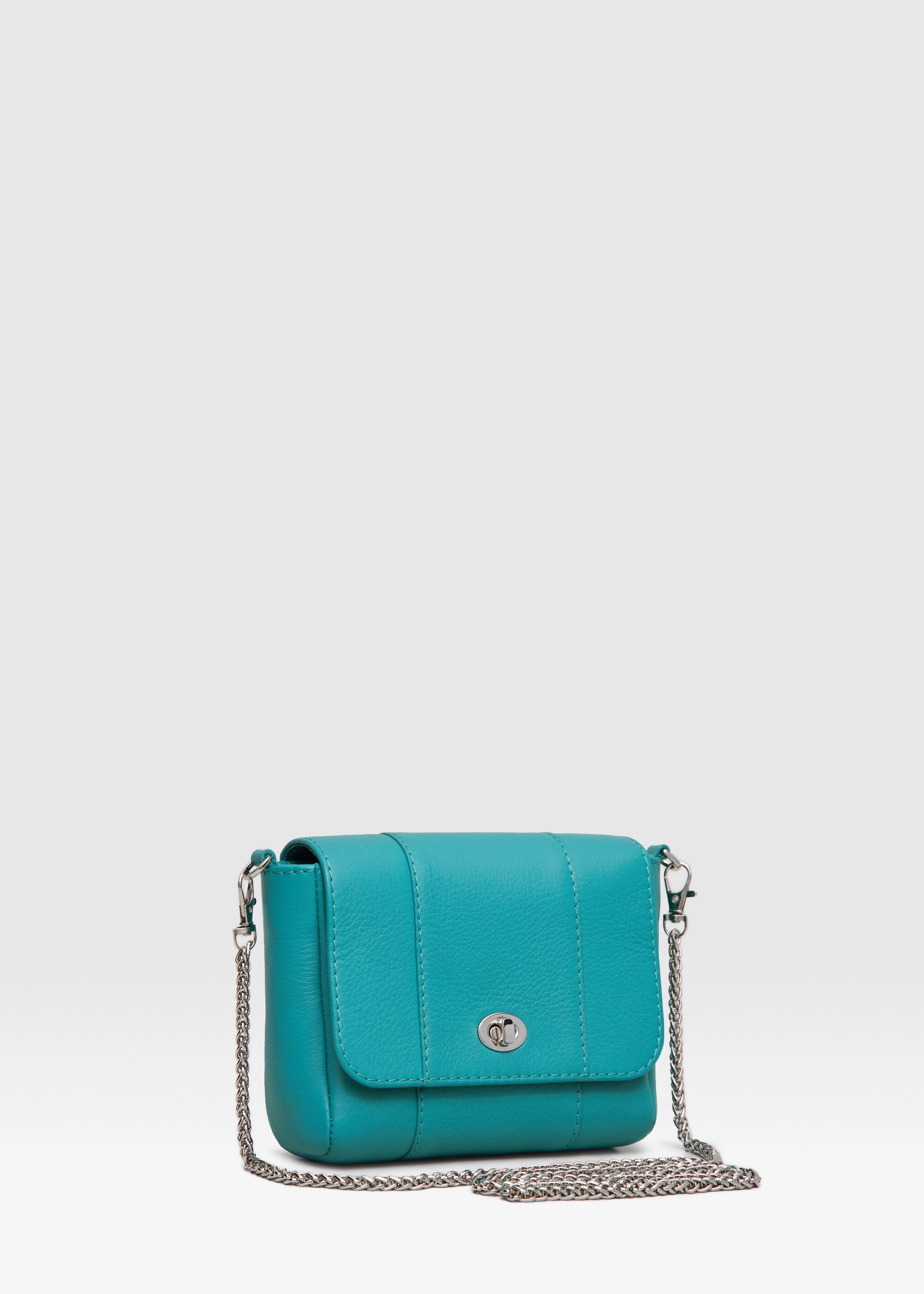Side view of the Philini Marina Mini Crossbody Bag in turquoise calf leather, rectangular silhouette with front flap, silver clasp, and shoulder chain. Compact and luxury accessory 