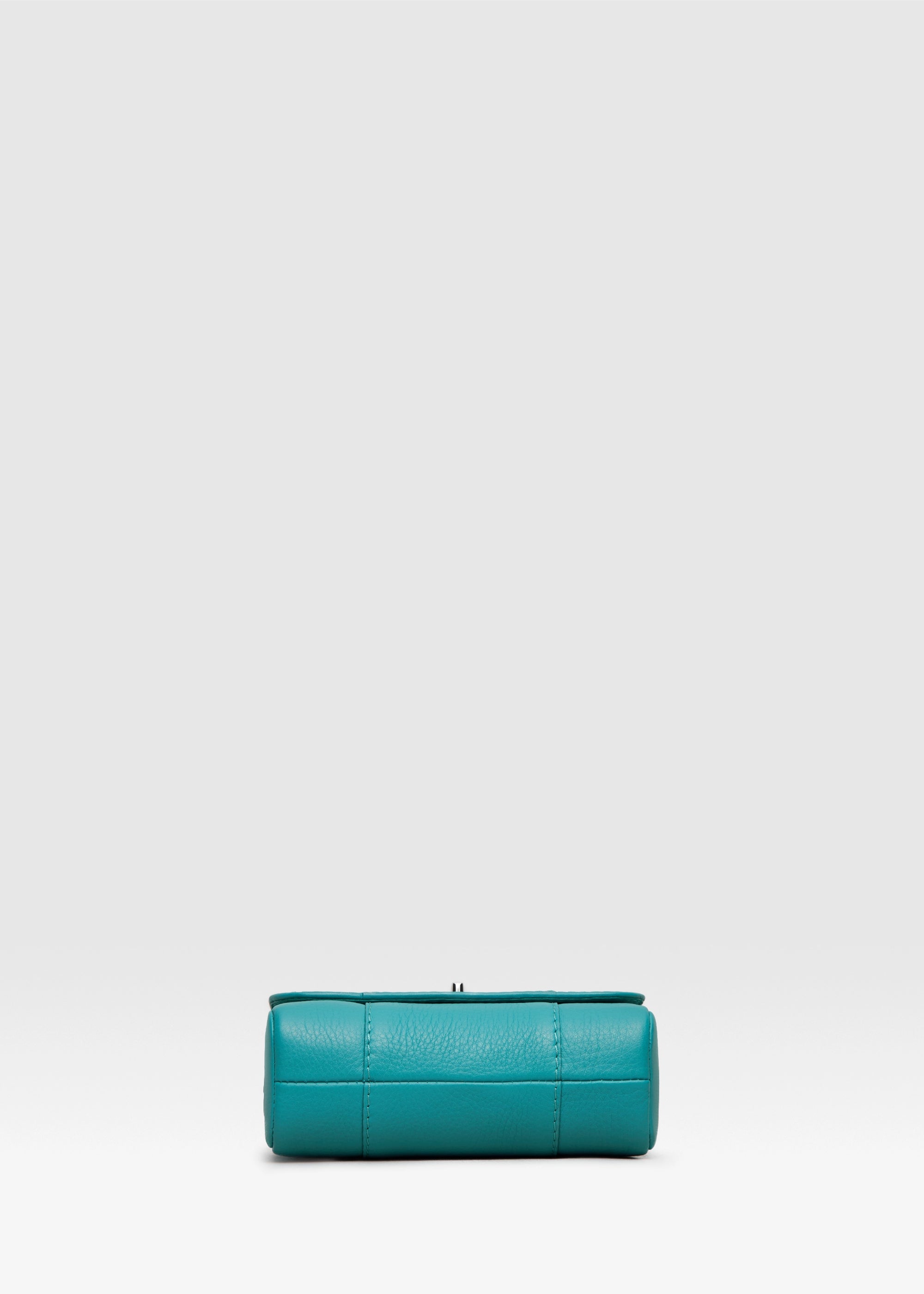 Bottom view of the Philini Marina Mini Crossbody Bag in turquoise calf leather, rectangular silhouette with front flap and silver chain shoulder strap. Handcrafted designer bag in a striking turquoise tone