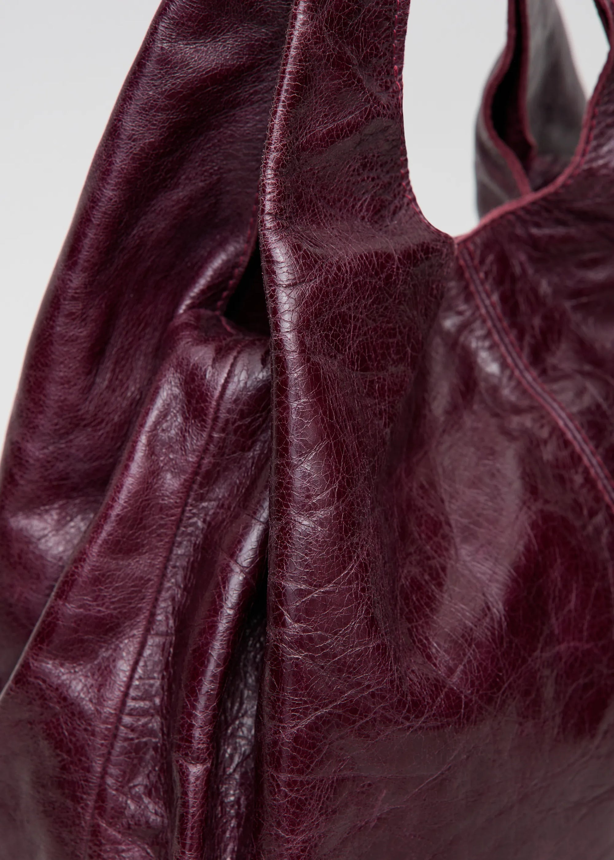 Detailed view of of Philini Melanie Burgundy Hobo Bag in soft calf leather with detachable strap and dual handles